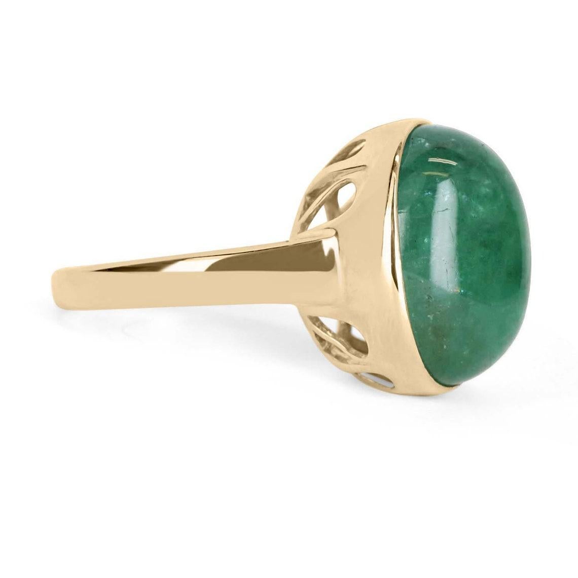 Displayed is a cabochon Colombian emerald solitaire ring in 14K yellow gold. This gorgeous solitaire ring carries a full 16.37-carat emerald in a secure bezel setting. The emerald is translucent and showcases a gorgeous green color. A one of a kind