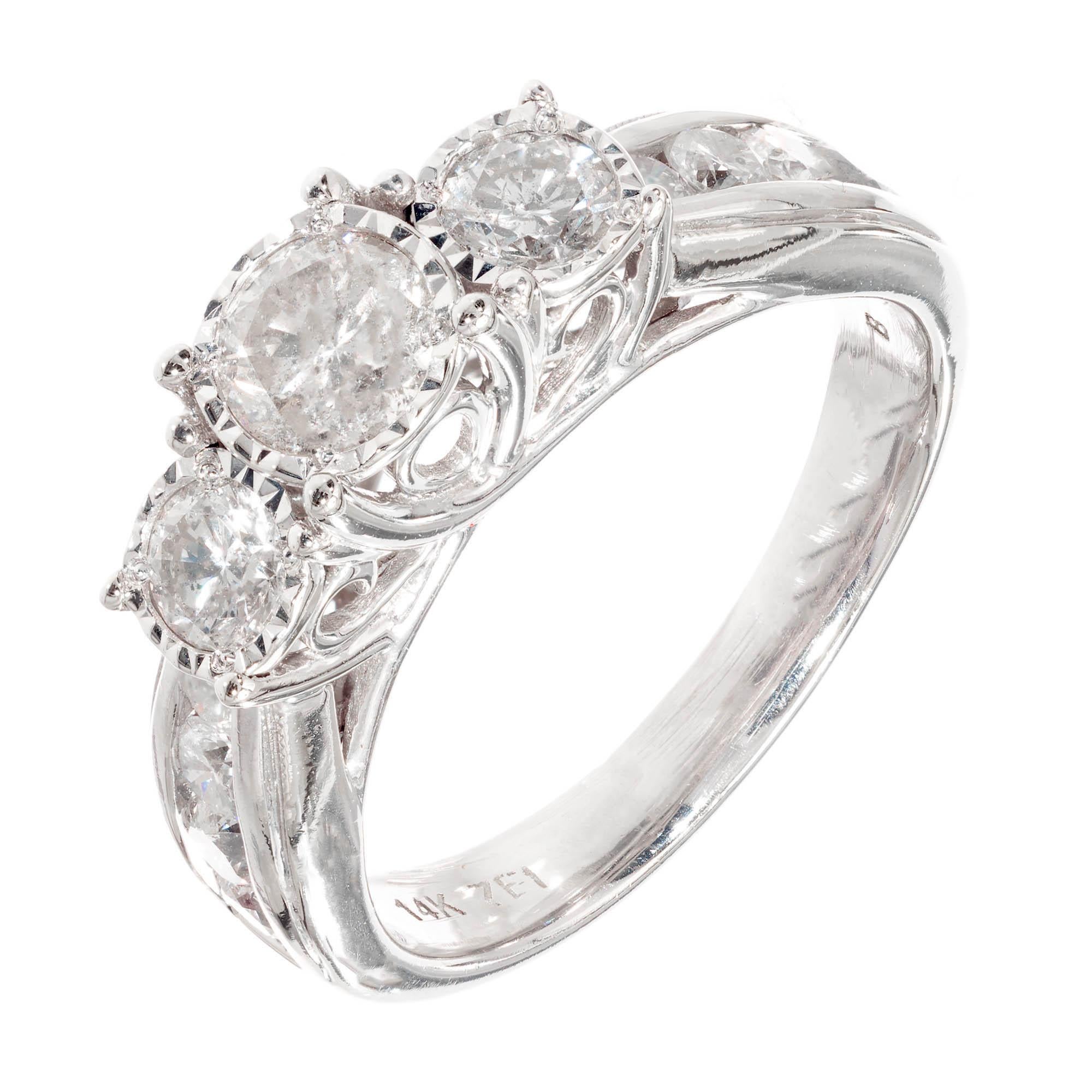 14k white gold three stone engagement style ring with side accent stones. Round brilliant cut diamonds are set across top of ring in faceted illusion style settings with an additional round brilliant diamonds channel set down each side of ring.

1