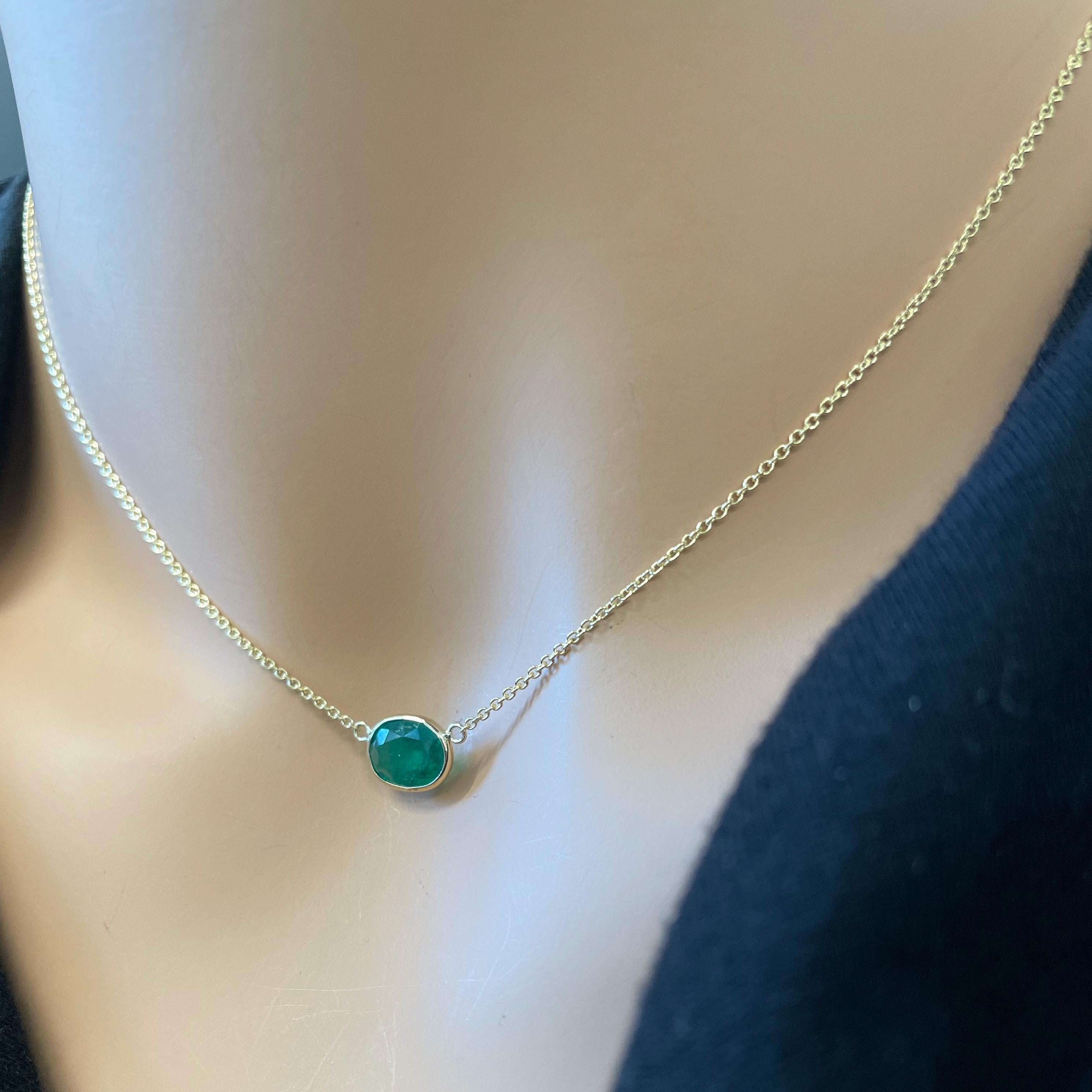 This necklace features an oval-cut green emerald with a weight of 1.64 carats, set in 14k yellow gold (YG). Emeralds are highly valued for their rich green color, and the oval cut is a classic and timeless choice for gemstones, offering an elegant