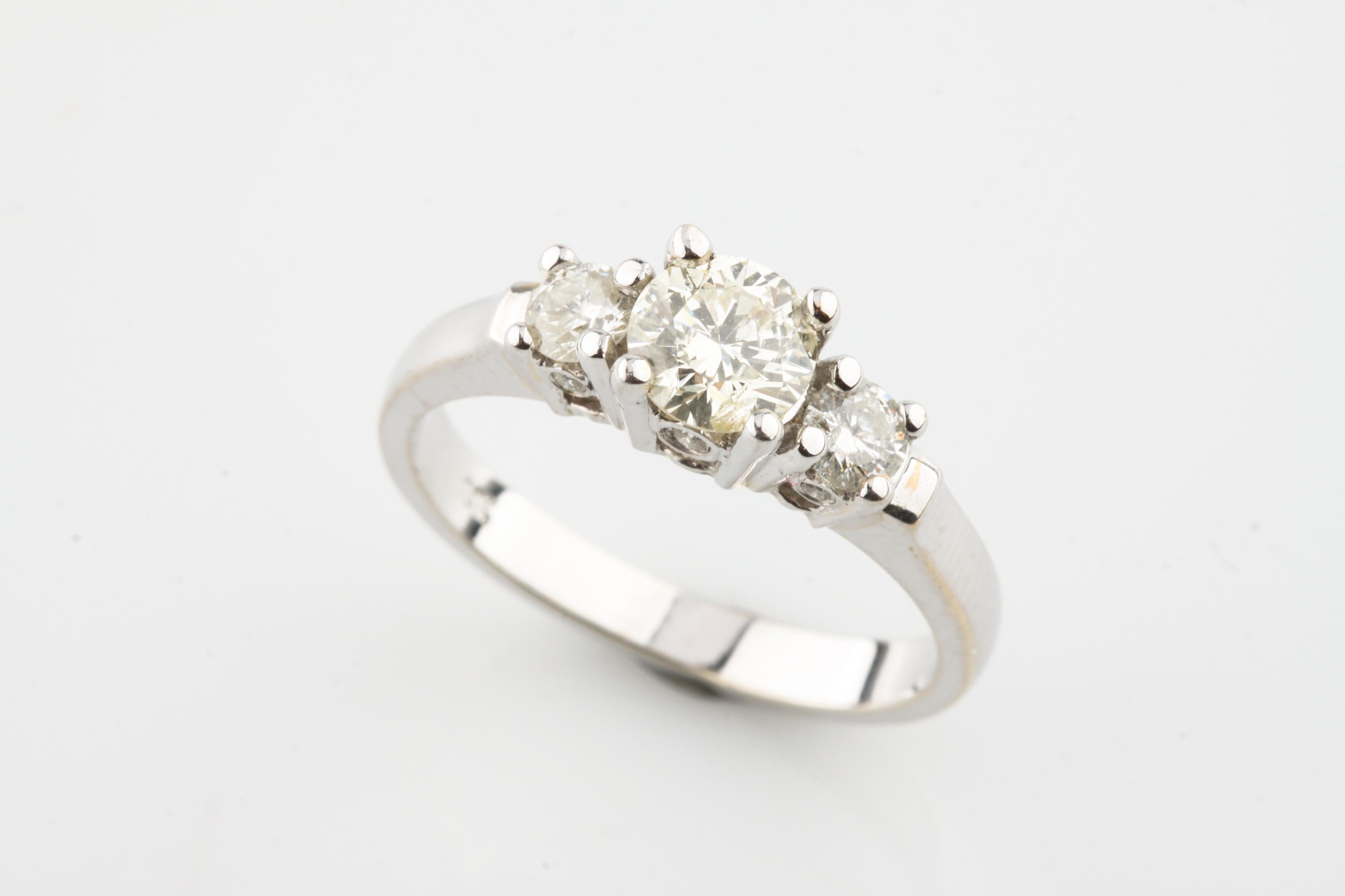 Un anello da donna in oro bianco 18KT fuso e assemblato con tre diamanti con finitura brillante.
Le condizioni sono nuove, di buona fattura. 
Identificato con il marchio 