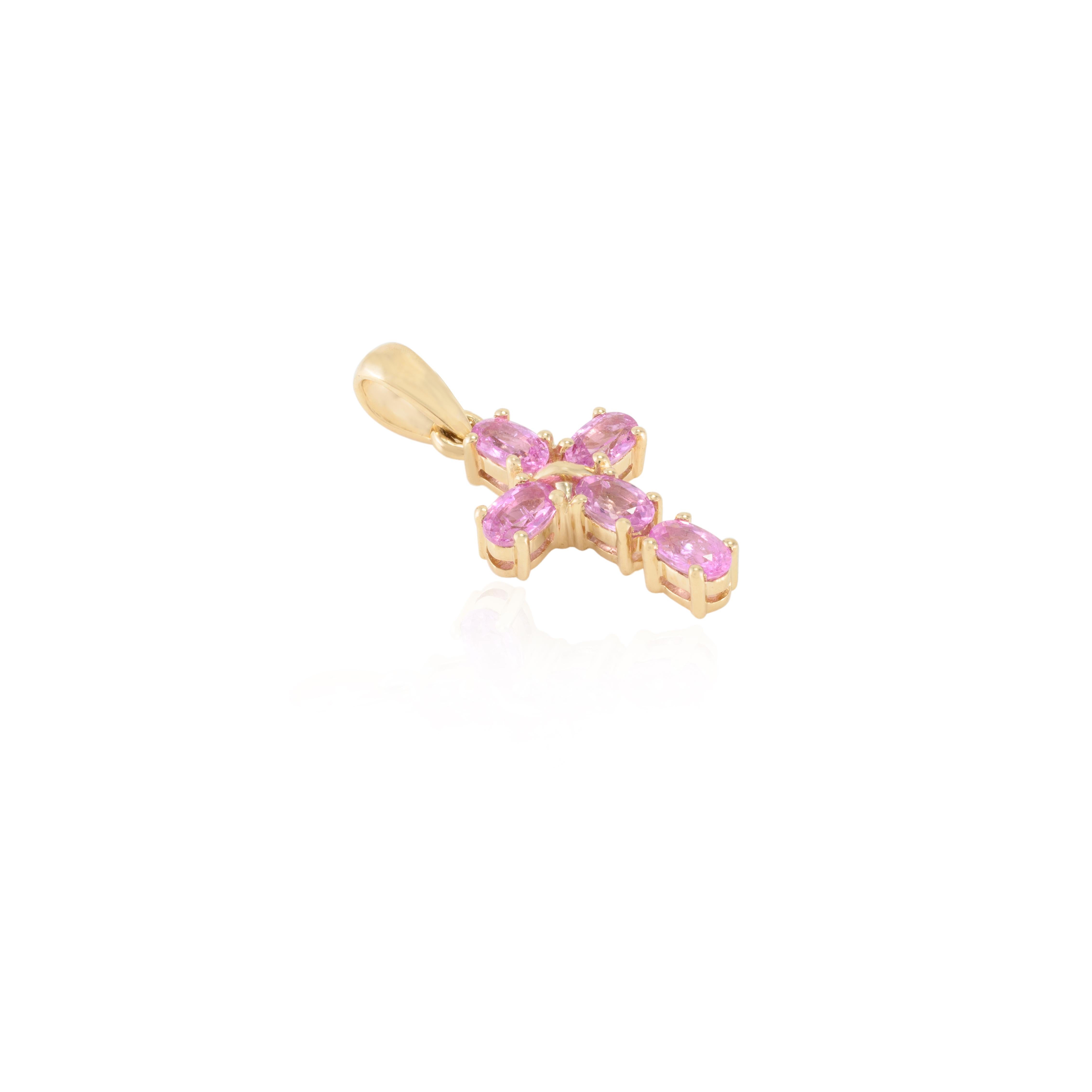 Natural Pink Sapphire Cross Pendant in 14K Gold studded with oval cut pink sapphire. This stunning piece of jewelry instantly elevates a casual look or dressy outfit. 
Sapphire stimulates concentration and reduces stress.
Designed with oval cut pink