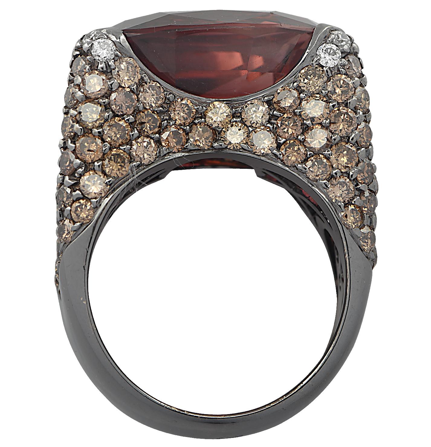 Stunning cocktail ring finely crafted in 18 karat white gold, plated with black rhodium, showcasing a spectacular oval shape Rubelite weighing approximately 16.40 carats, accented by mixed white and brown round brilliant cut diamonds, weighing