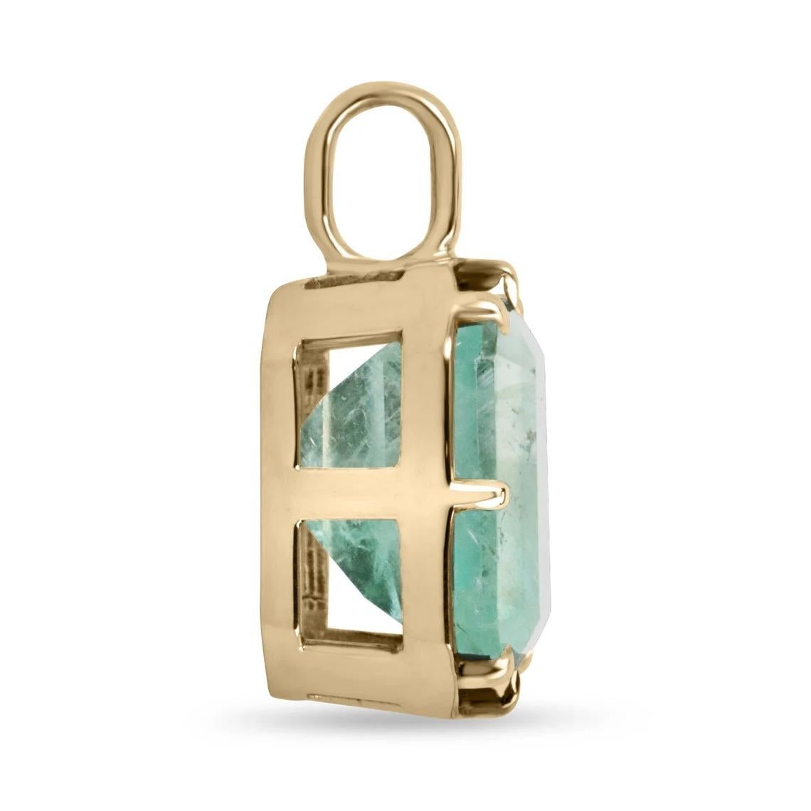 Displayed is a natural emerald Georgian-styled solitaire pendant in 14K yellow gold. This gorgeous solitaire pendant carries a full 16.40-carat Colombian emerald in a prong setting. Black rhodium highlights the emeralds' bezel and prongs. Fully