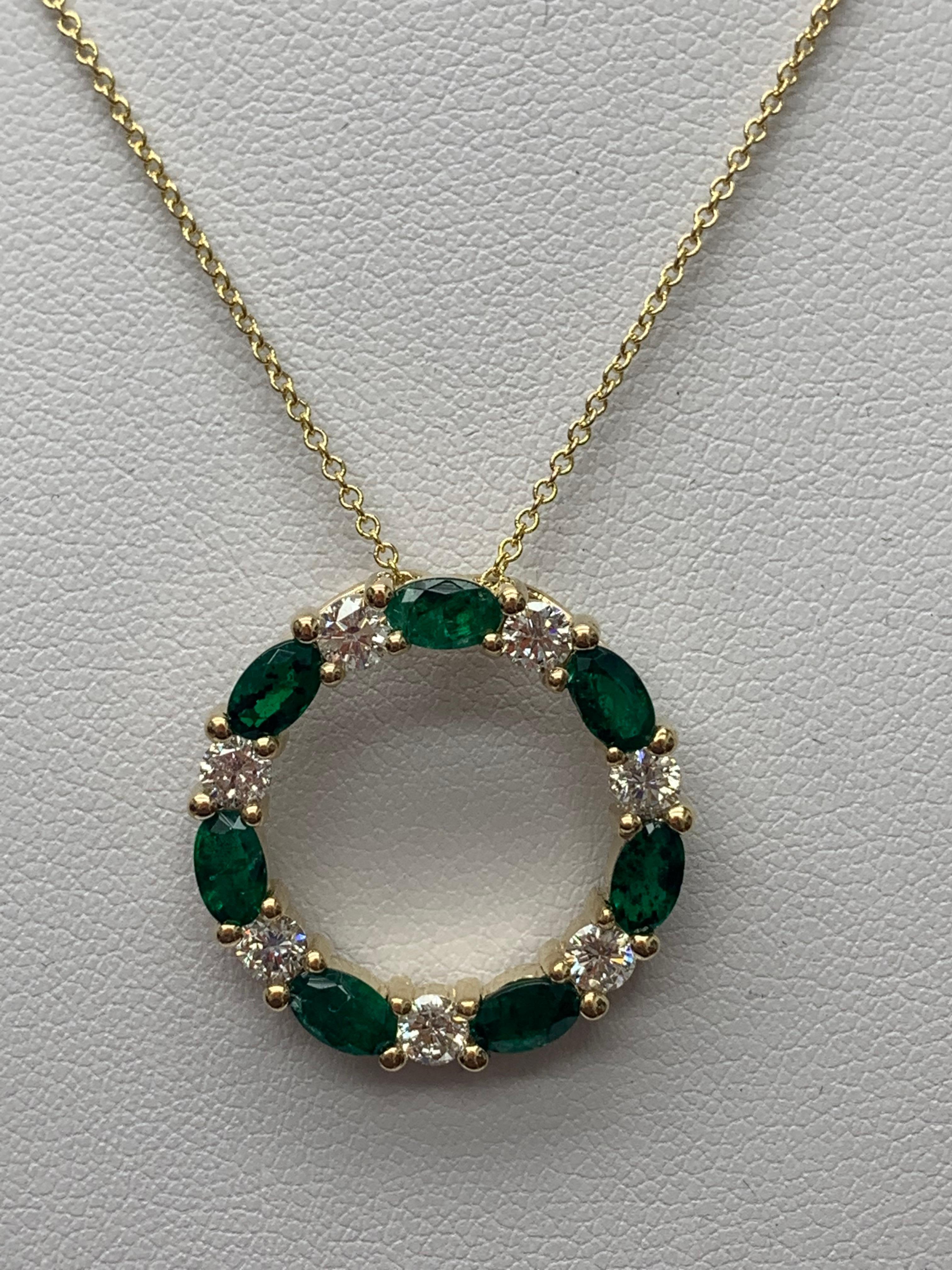 A stylish pendant necklace showcasing a row of Emerald alternating diamonds, set in an open-work, circular design. 7 oval shape emeralds weigh 1.65 carats and 7 brilliant-cut diamonds weigh 0.71 carats in total. All diamonds are GH color SI1