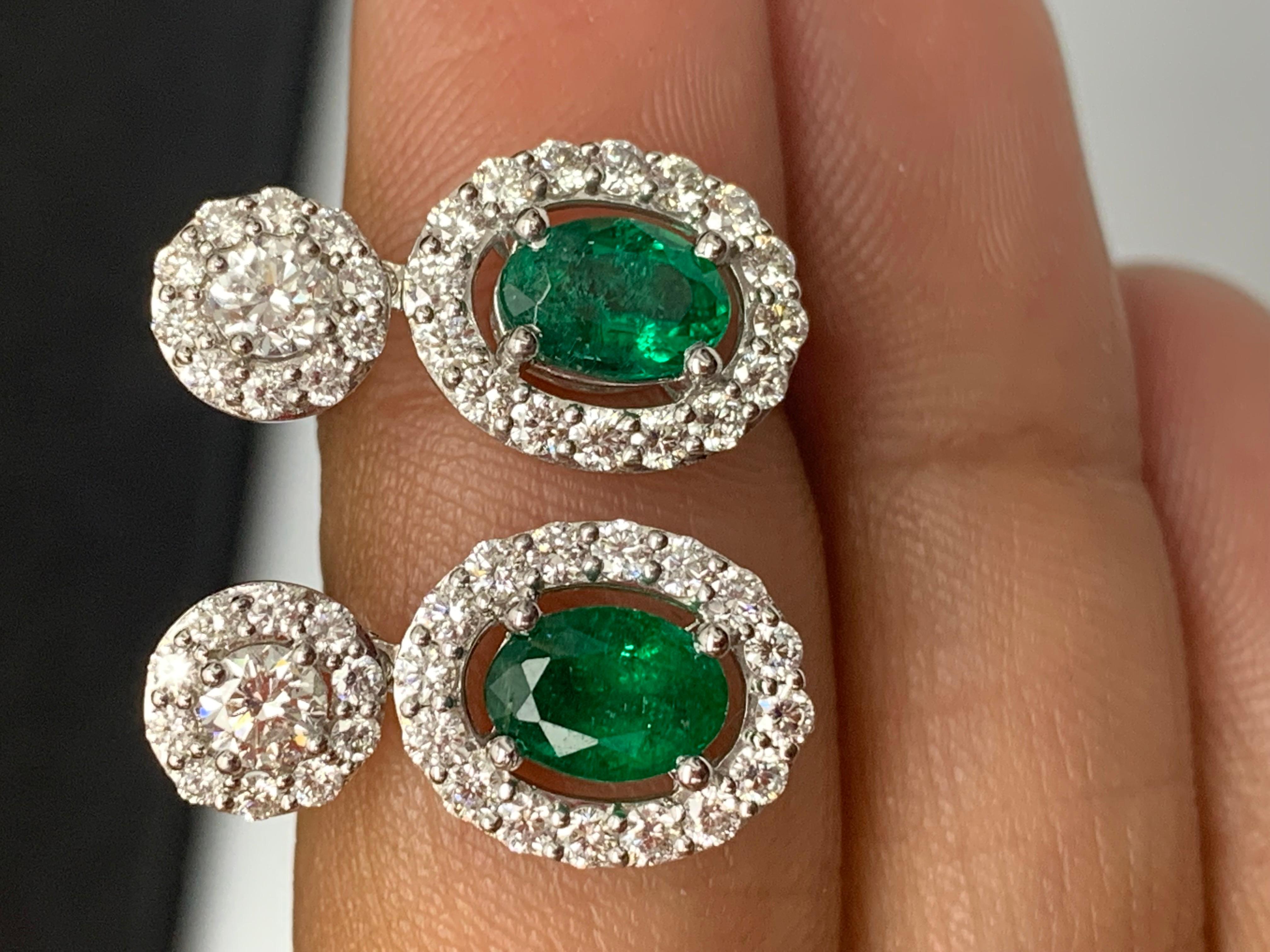 A beautiful and chic pair of drop earrings showcasing brilliant-cut diamonds, and oval-shaped Emeralds set in an intricate and stylish design. 2  Diamonds on the top weigh 0.37 carats in total.  2  emeralds weigh 1.65 carats in total. Made in 18k