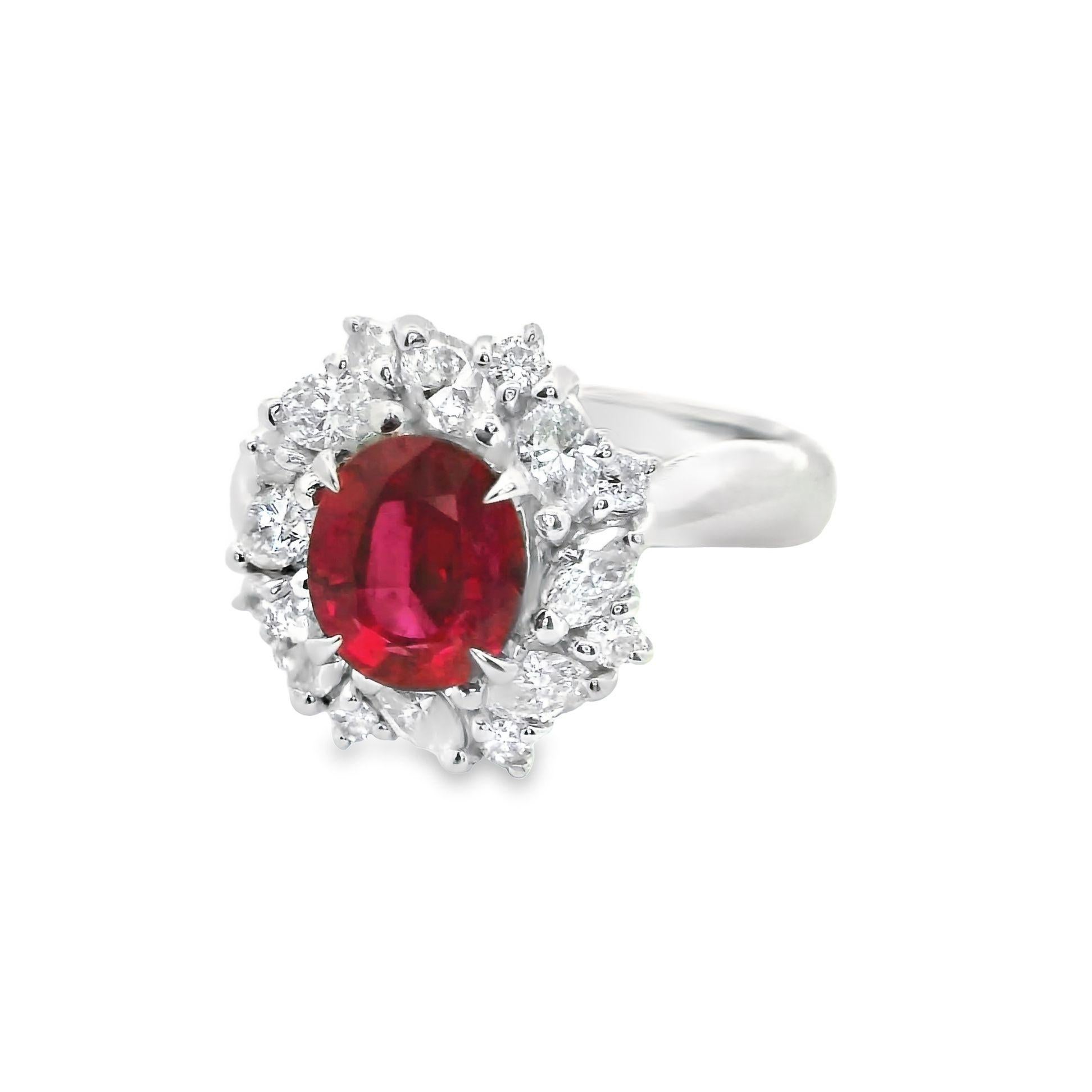 A lovely natural ruby weighing 1.65 carats takes center stage of this diamond platinum ring. The ruby has a bright and vibrant pure-red color and is certified by the GIA as natural with a Thai origin. Surrounding the ruby are 0.89 carats of marquise