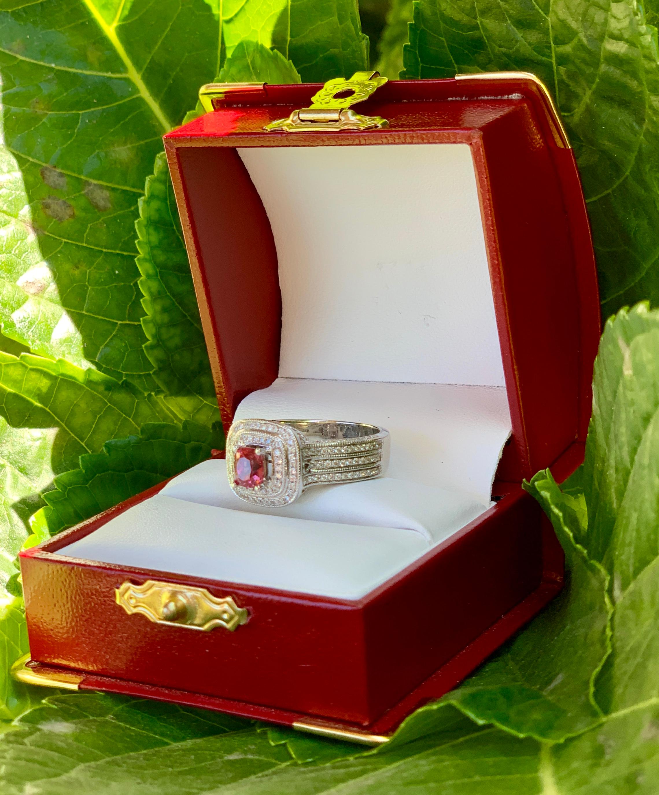 Elegant 1.65 carat ring features a vivid and sparkling, rectangular cushion cut pink sapphire prong set in 14 karat white gold and surrounded by a stepped, double diamond micro pave halo.  Ring is beautifully detailed, with 3 rows of micro pave