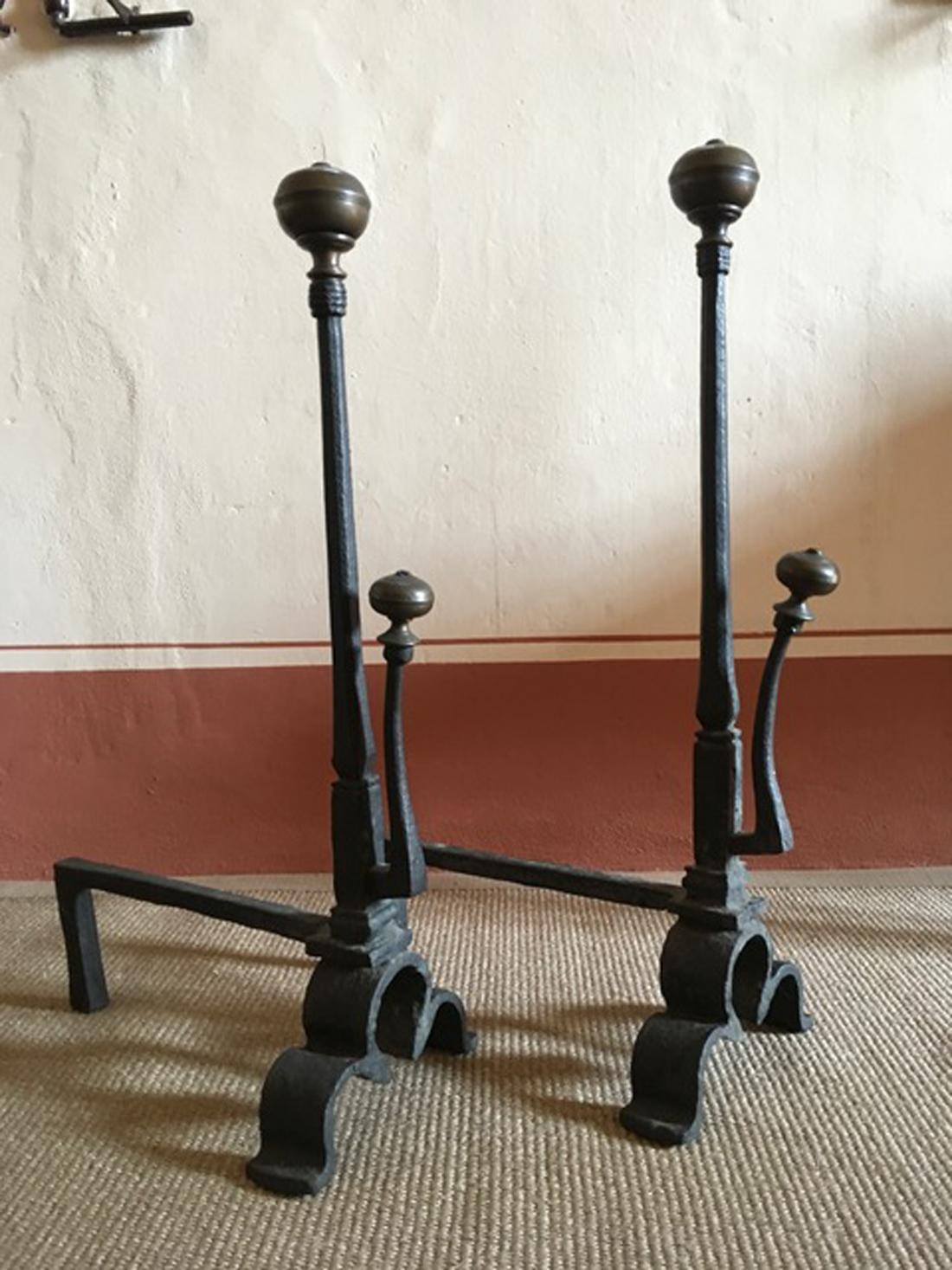 This pair of black wrought cast iron Italian fireplace andirons have a great charm. There is a brass bowl on the rod top.
They are coming from a fair century of the past.
The irregular form dues to age and use.

With certificate of authenticity.