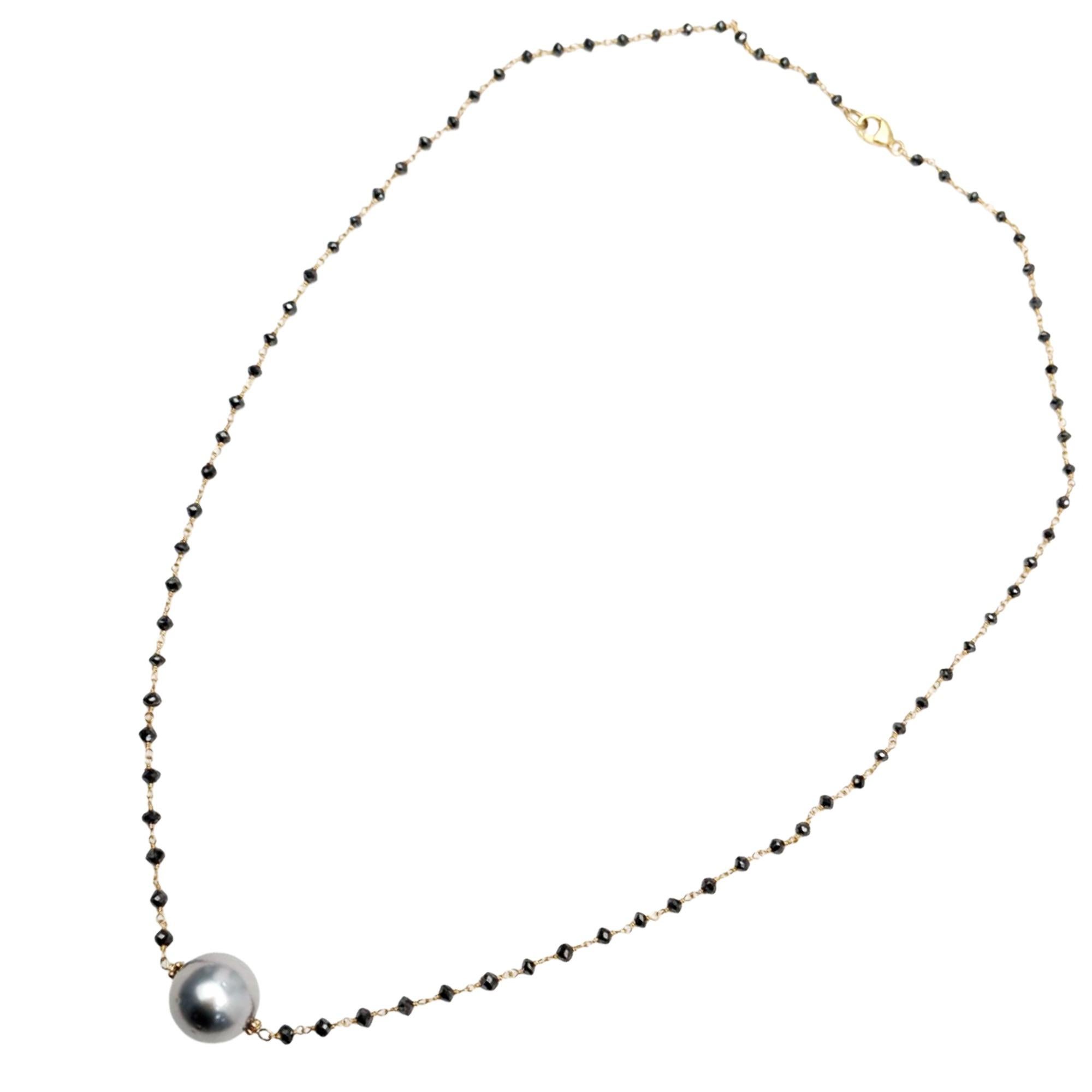 Bold, modern, and elegantly refined, this 16.5-inch rosary necklace features hand-linked black diamond beads crafted with 14K yellow gold wire for a sleek, luminous strand. At the center, a single round grey Tahitian pearl drop adds a sophisticated