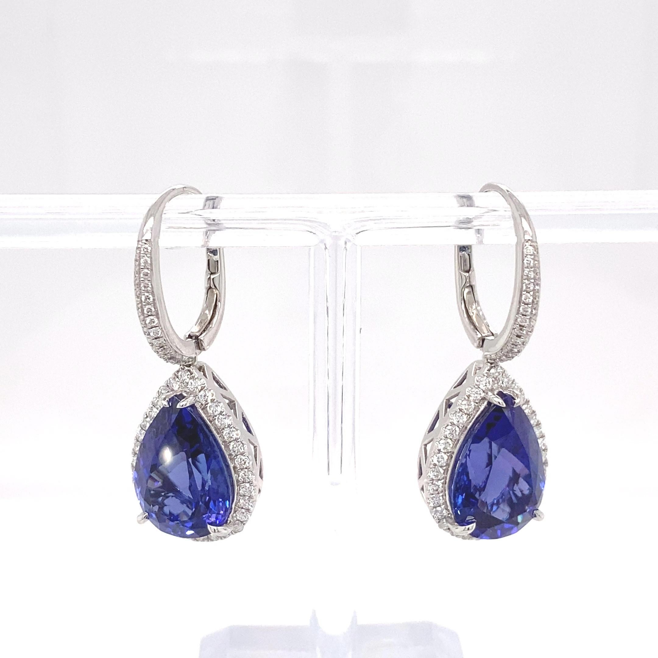 Diese eleganten Ohrringe haben 16,51 Karat Birne  Form eines Tansanits, der von einem Halo aus weißen Diamanten umgeben ist und auch auf der Glocke Diamantakzente aufweist. Die lebendige violette Farbe Tansanit ist sorgfältig mit Detailarbeit von