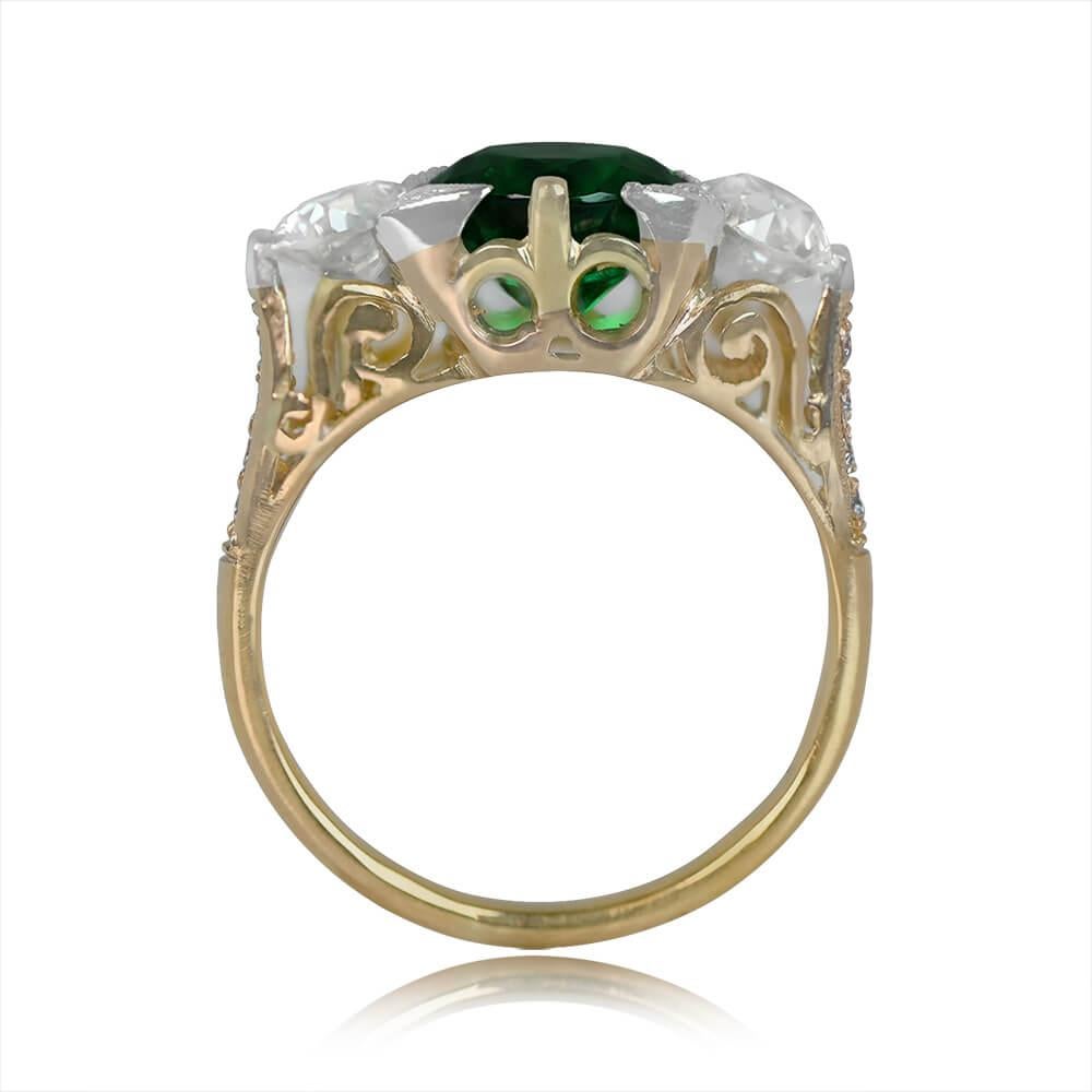 A captivating three-stone ring stars a 1.65-carat round-cut natural emerald, embraced by prongs. Flanking the center gem are old European cut diamonds, totaling 1.08 carats, with K-L color and VS1 clarity. Additional small old European cut diamonds