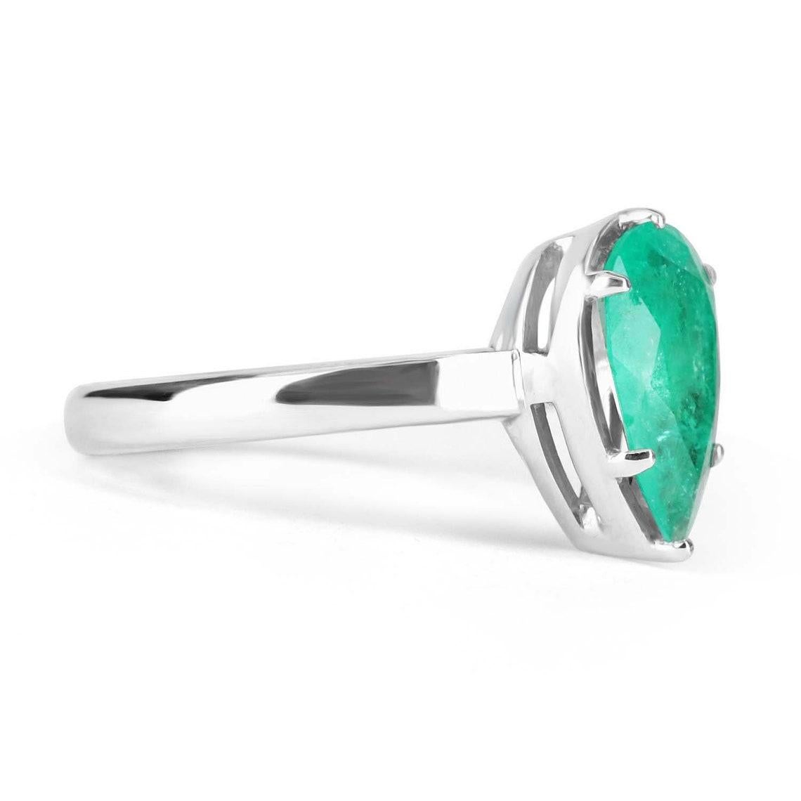 Displayed is a custom emerald solitaire pear-cut engagement/right-hand ring in 14K white gold. This gorgeous solitaire ring carries a 1.65-carat emerald in a six-prong setting. The emerald has very good clarity with minor flaws that are normal in