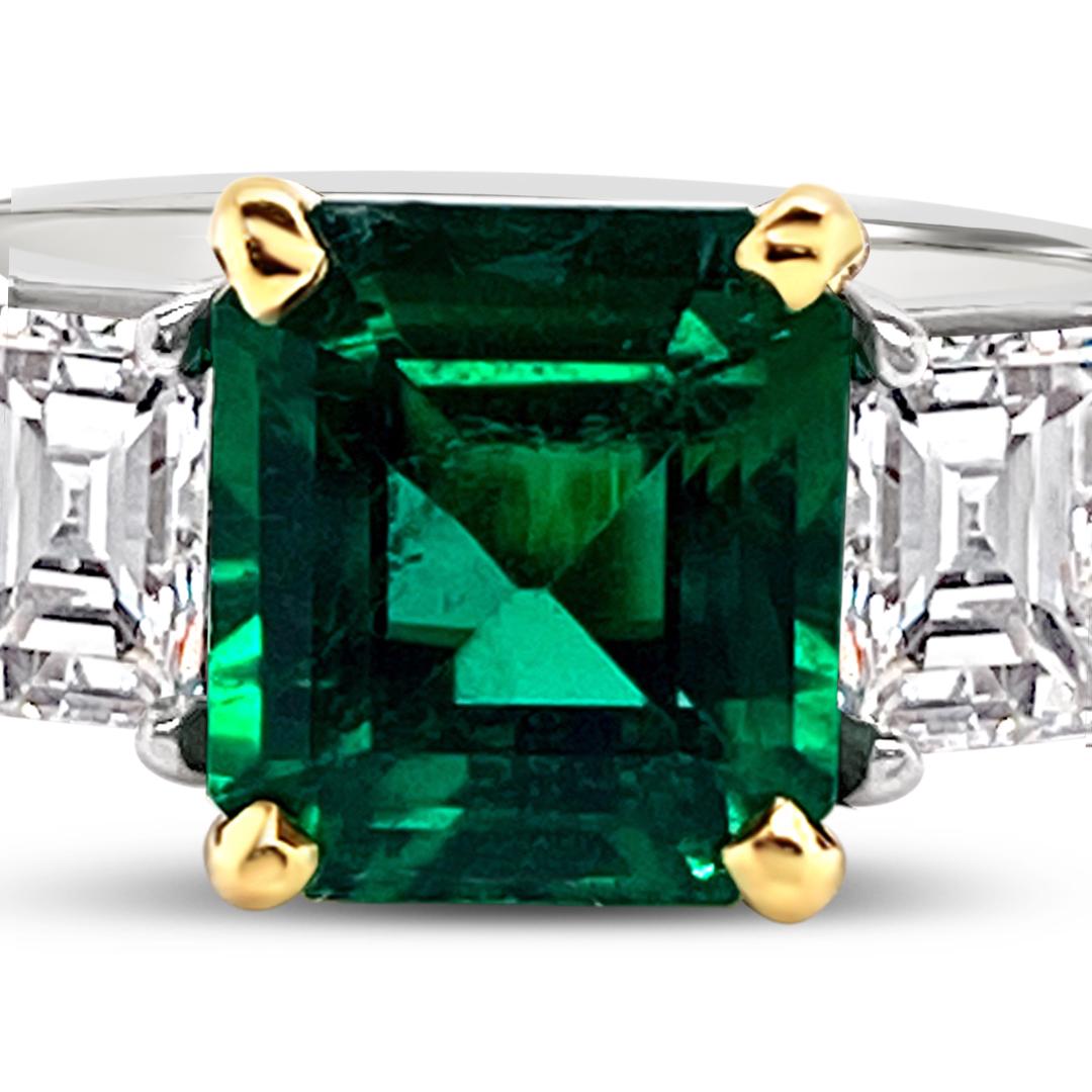 1.66 Carats Emerald Ring side set with 1.06 Carats (total weight) Emerald Cut Diamonds. Set in Platinum with 18K Yellow Gold center mounting.
