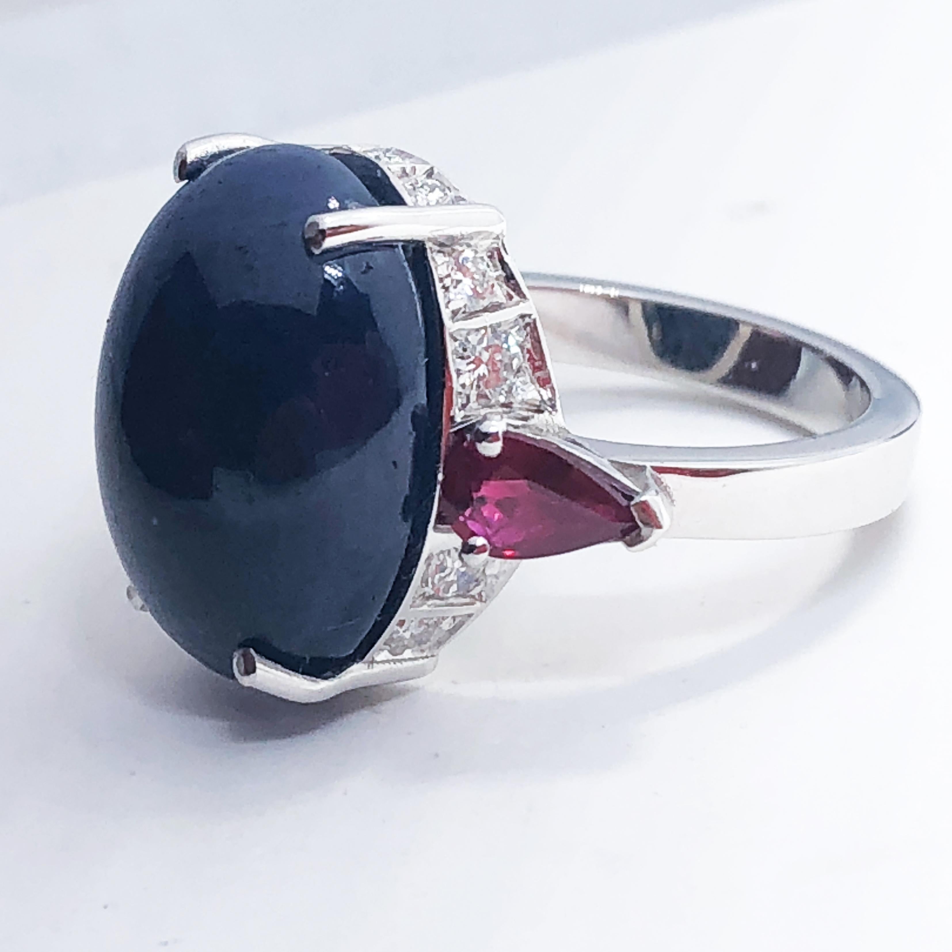 One-of-a-kind Cocktail Ring featuring a 16.60 Carat Natural Oval Sapphire Cabochon, two 0.40 Carat Ruby drops in a chic white diamond 18K white gold setting.

US Size 6 1/4 French Size 53
We offer complimentary resizing on this piece