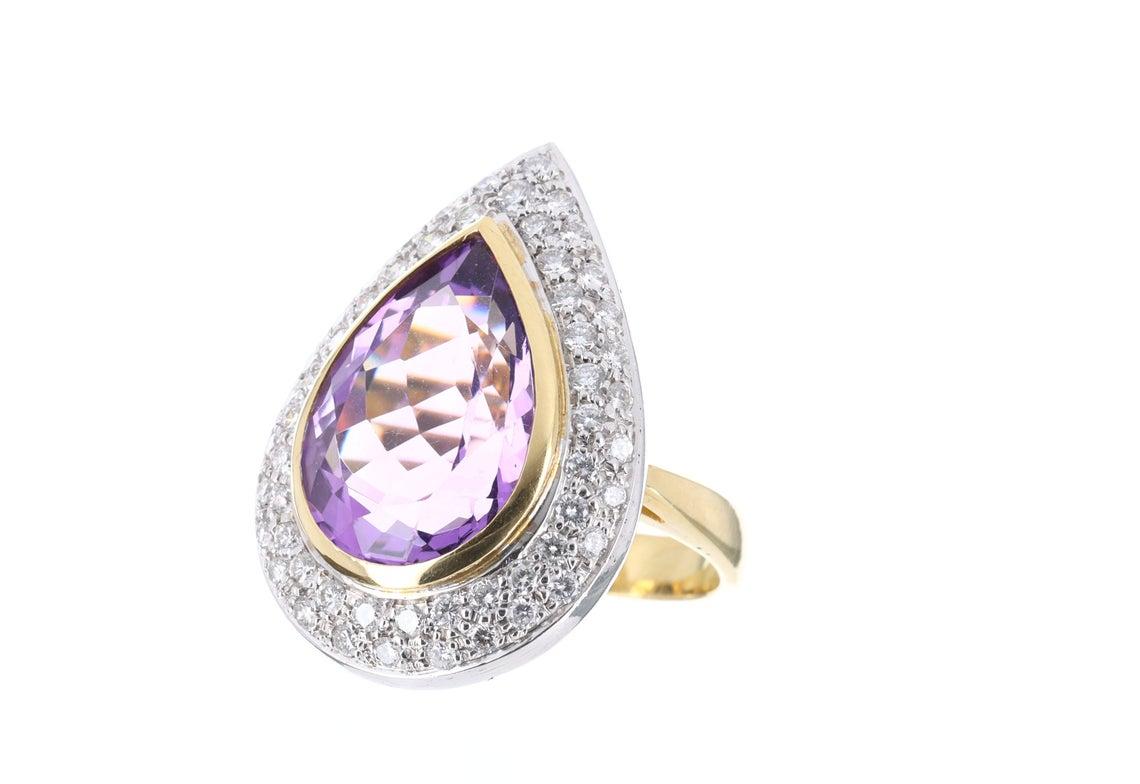 Indulge in the best quality there is with this stunning, high quality amethyst and diamond 18K two-toned ring. A effervescent purple color is evenly distributed in this AAA+ quality gemstone. 15.53cts of pure luster and vivaciousness are set in a