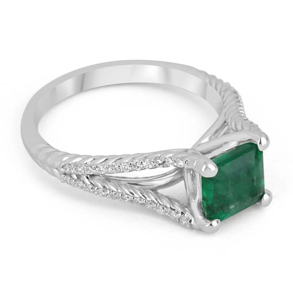 A dazzling emerald and diamond ring. This beautiful piece features a 1.41-carat, natural Zambian Asscher cut emerald. The gem displays a vivid dark green color, and very good clarity. Securely four prong-set, with a split shank that has multiple