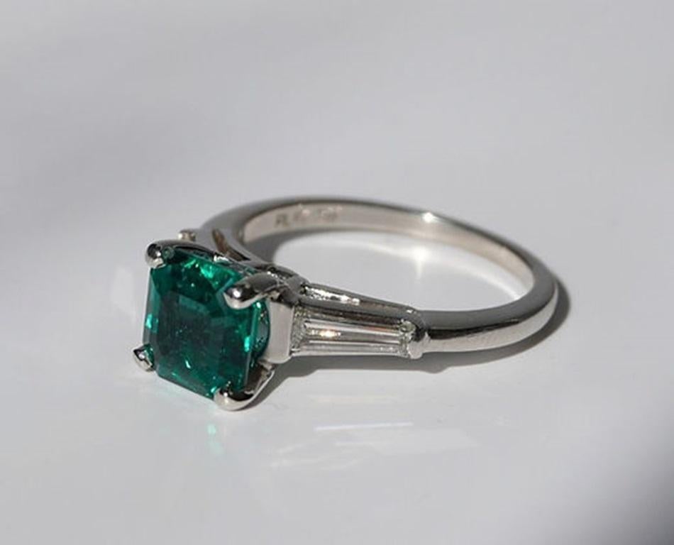 Emerald Weight: 1.67 ct, Measurements: 7.27 x 7.18 mm, Diamond Weight: 0.50 ct, Metal: Platinum, Metal Weight: 4.77 gm, Ring Size: 6.5, Shape: Emerald-Cut, Color: Vivid Green, Hardness: 7.5-8, Birthstone: May, Origin: Zambia