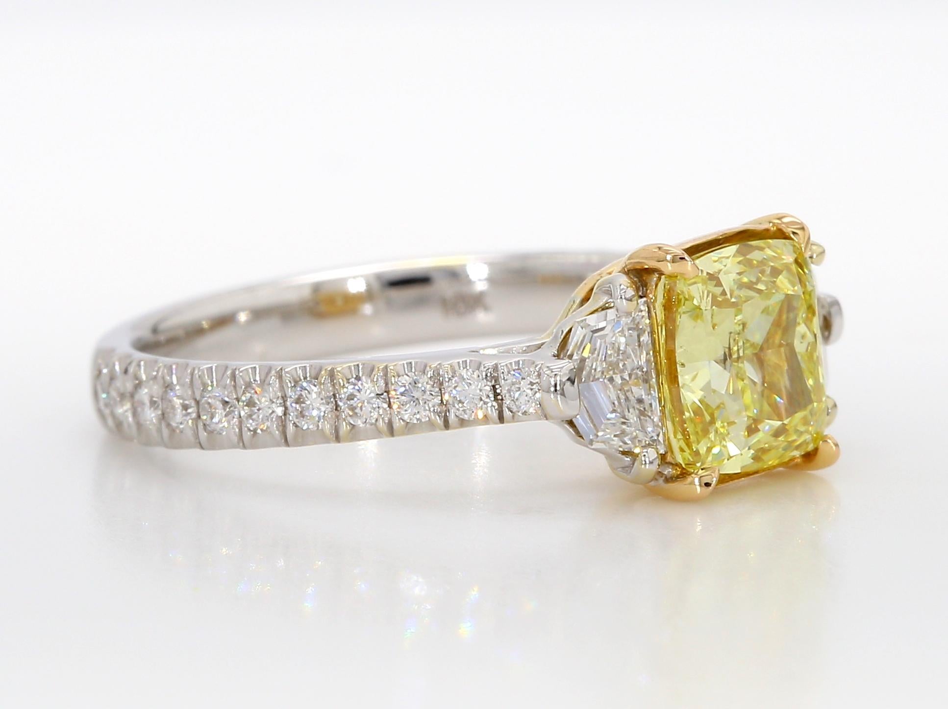 Presenting an exquisite Three-Stone Engagement Ring showcasing a breathtaking 1.67-carat Fancy Intense Yellow, Cushion-cut diamond. GIA has meticulously certified this diamond as SI2 in clarity. The stones exhibit an excellent polish and an