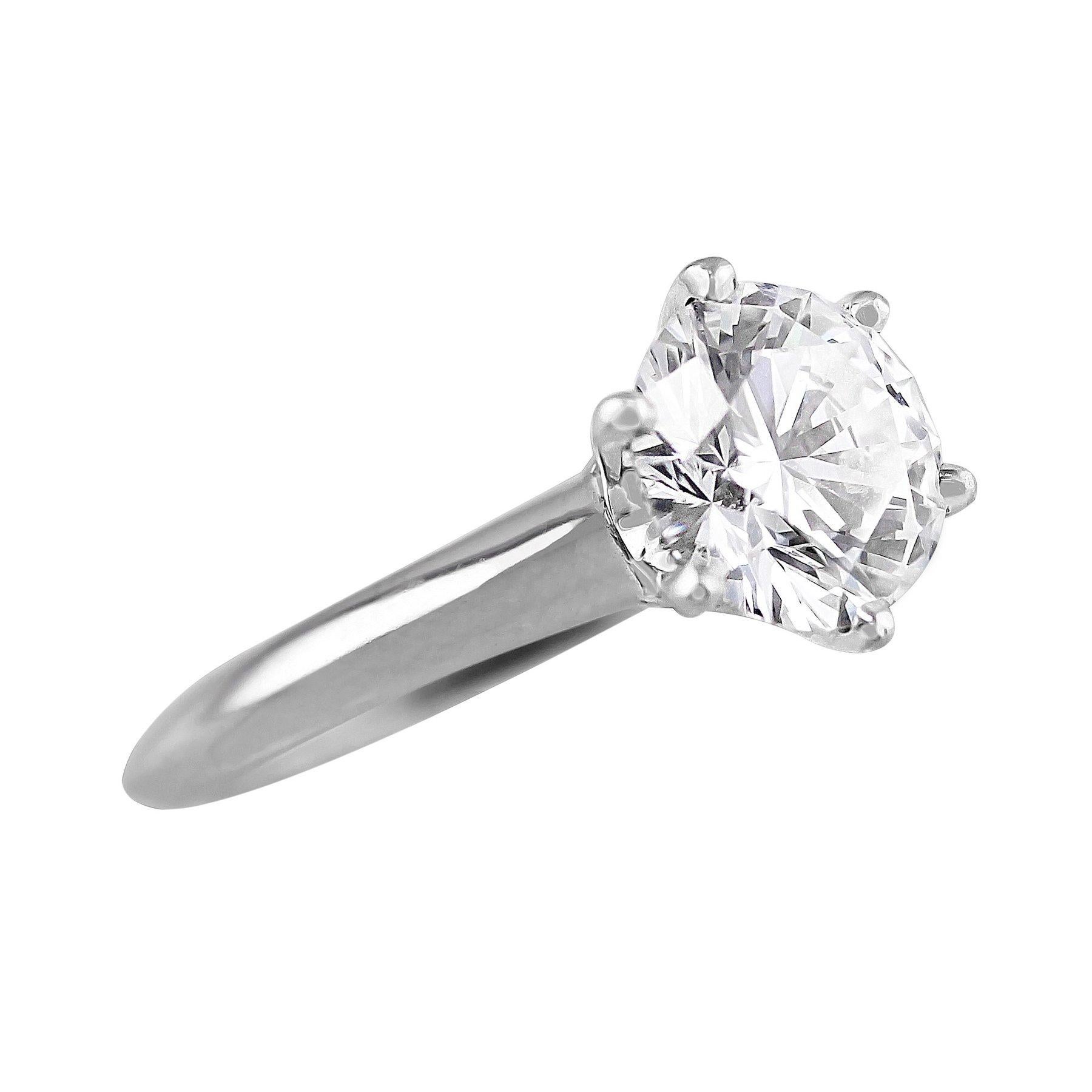 This is the classic Tiffany Setting ring, a lovely diamond and platinum solitaire. The round brilliant cut diamond weighs 1.67cts and is GIA certified with D color and VVS2 clarity. The D color grade represents the highest most pure color grade