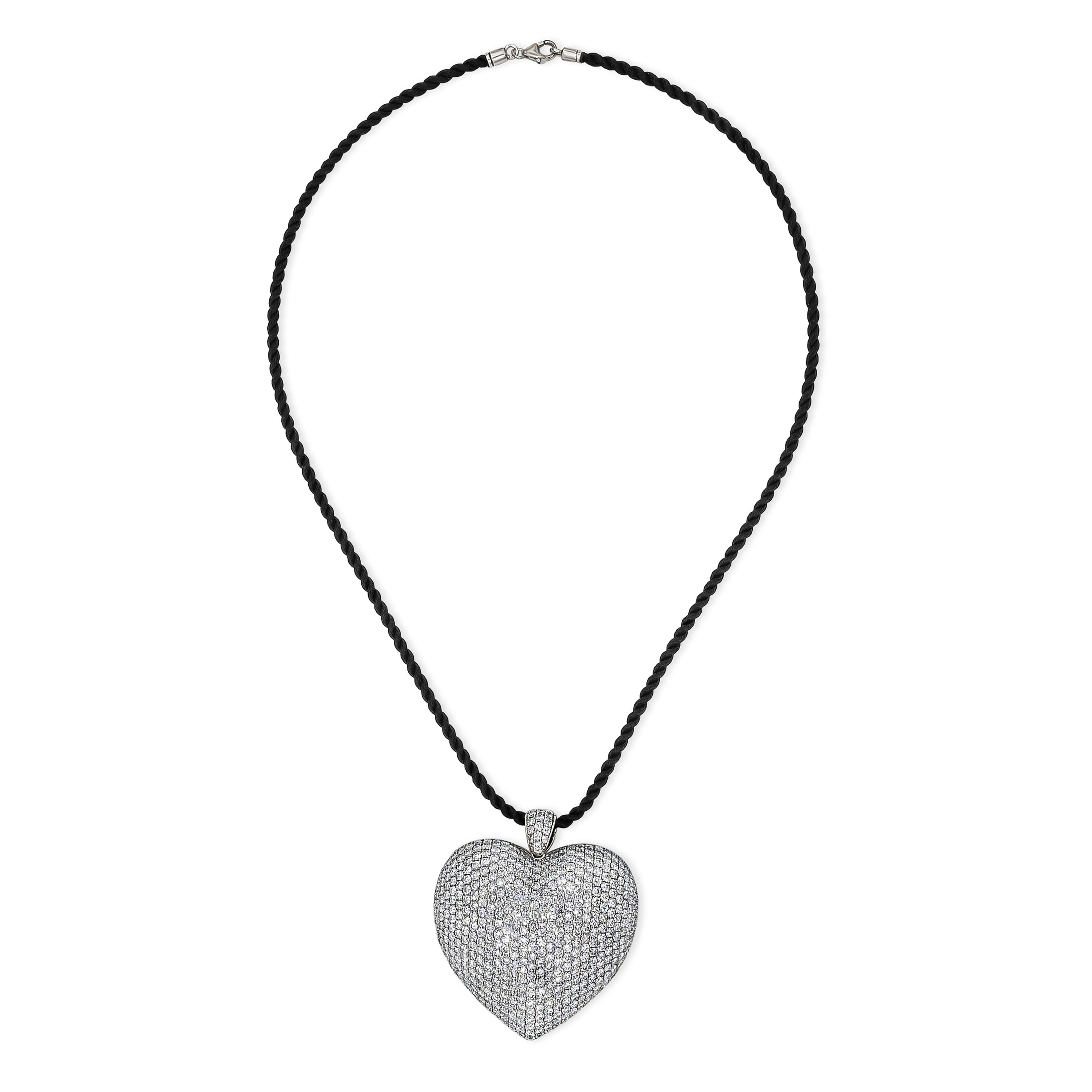 An important and beautiful pendant necklace showcasing a cluster of round brilliant diamonds set in a domed heart shape pendant made in 18k white gold. Diamonds weigh 16.70 carats total. Suspended on a 18 inch rope. 

Style available in different