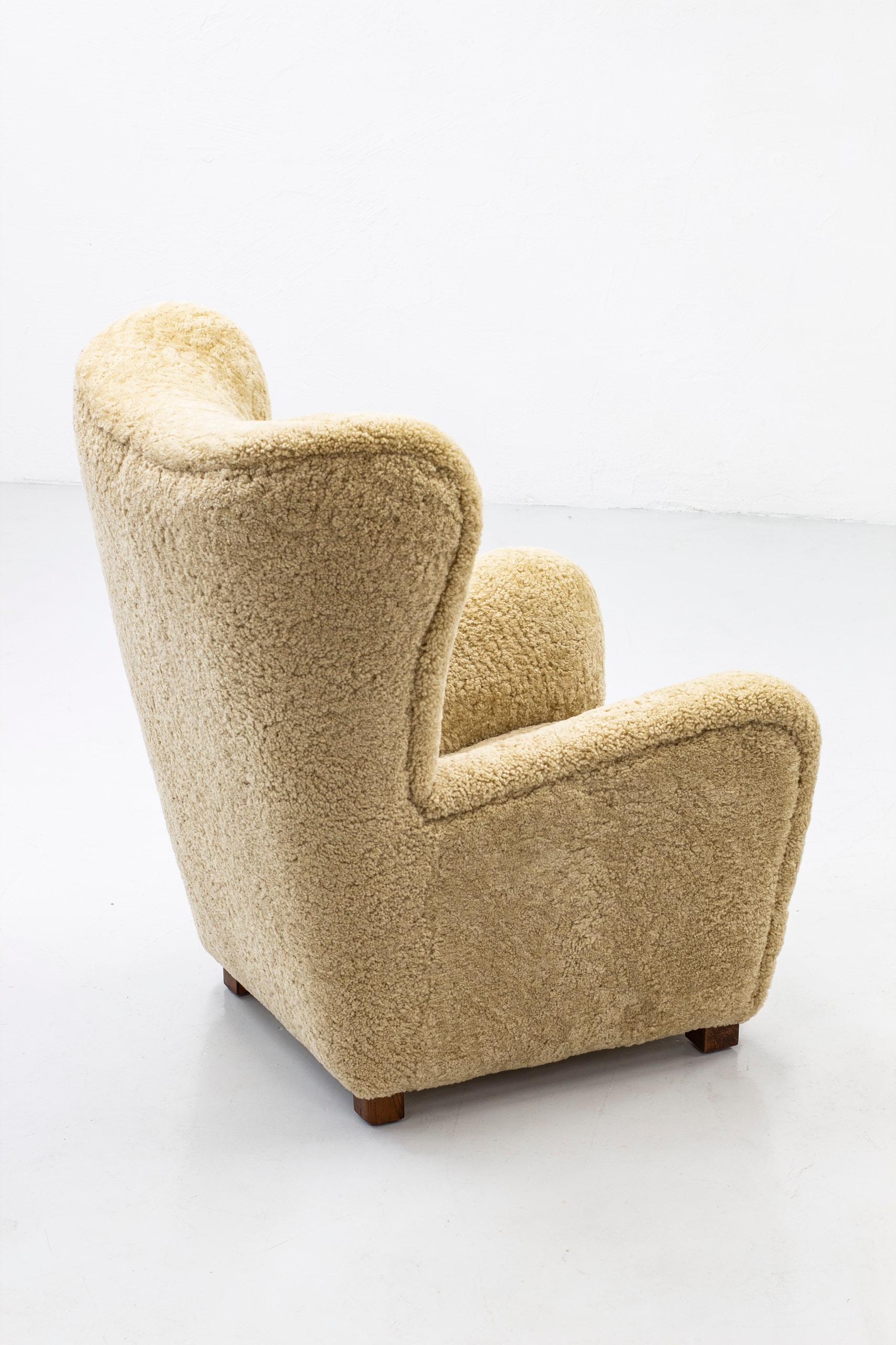 Großer Lounge-/Lehnsessel Modell 1672 von Fritz Hansen. Hergestellt in Dänemark in den 1930-40er Jahren. Dunkel gebeizte Eichenbeine und neues hellbeiges Schafsleder mit getufteten Lederknöpfen im Rücken. Sehr guter Zustand. Beine neu lackiert und