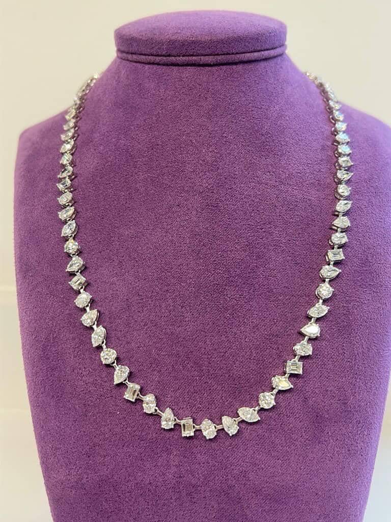 Un remarquable collier de tennis en diamant de 16 pouces présentant un arrangement artistique de diamants de différentes tailles, y compris des diamants ronds de taille brillant, marquise, émeraude, ovale et poire. Chaque diamant pèse en moyenne