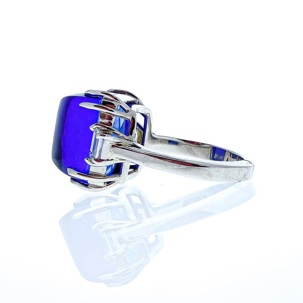 This spectacular 18 karat white gold custom made cocktail ring truly displays the incredible beauty of the tanzanite. A gorgeous intense bluish-purple sugar loaf tanzanite is prong set in the center with a weight of 16.75 carats. Two shimmering