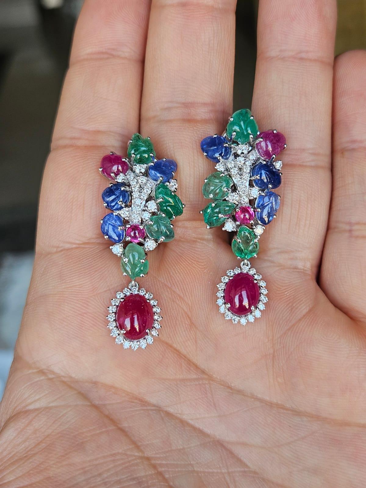 Boucles d'oreilles chandelier en or blanc 18 carats, saphirs bleus, émeraudes et rubis, très modernes et magnifiques, serties de diamants naturels. Le poids combiné du cabochon de rubis, des saphirs bleus sculptés, des émeraudes et des rubis est de