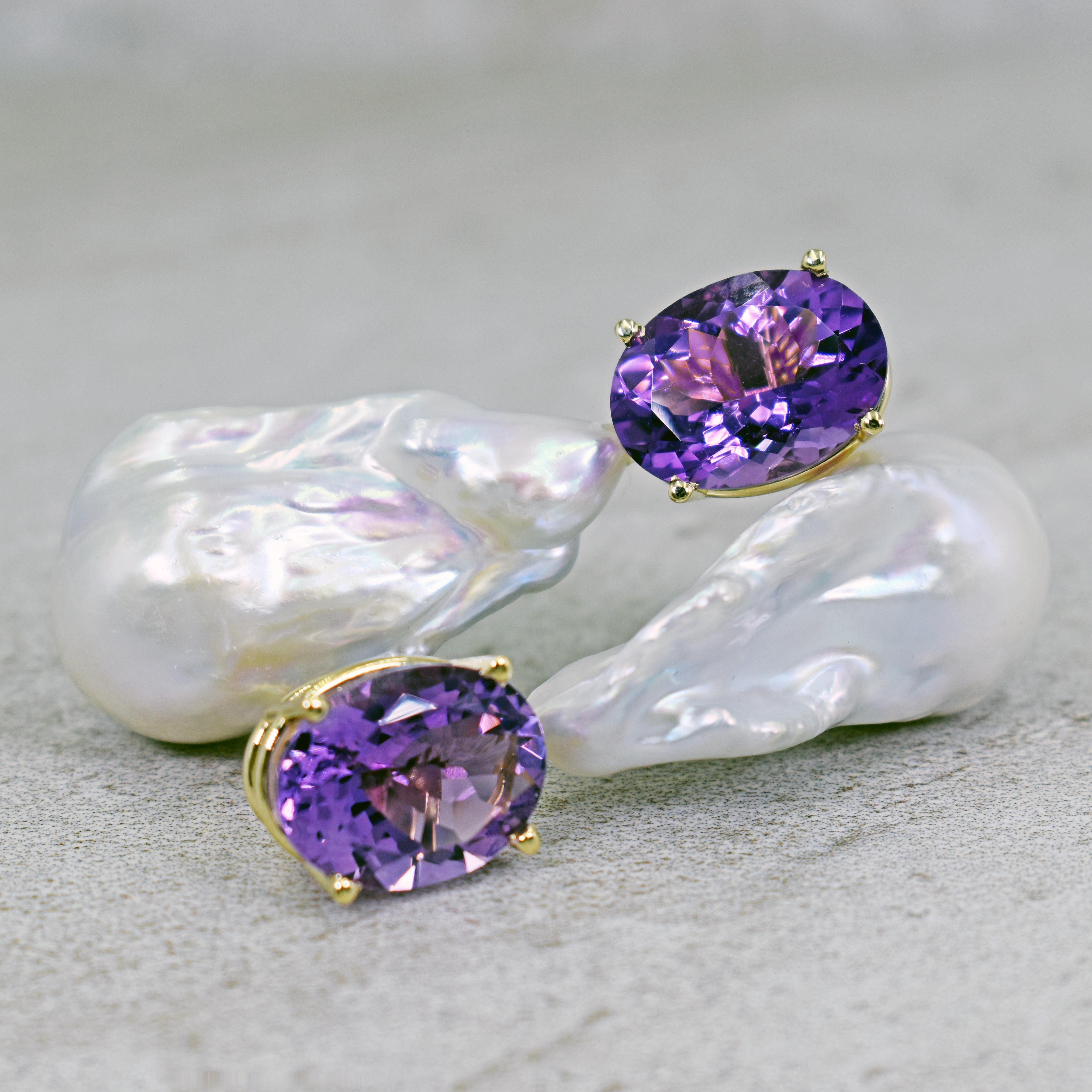 Gorgeous and unique 14k yellow gold stud earrings featuring two oval-cut Amethyst gemstones, totaling 16.79 carats, with large Freshwater Baroque Pearls. Stud earrings are 2.19 inches or 55 mm in length. These artisan statement earrings have