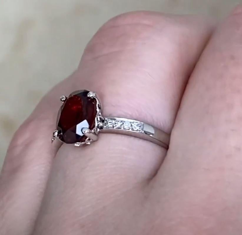 This exquisite engagement ring showcases a captivating approx. 1.60-carat garnet center stone, masterfully prong-set in luxurious 14K white gold. The deep, rich hue of the garnet is beautifully complemented by the brilliance of pave-set round