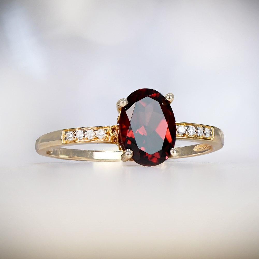This captivating birthstone ring showcases a 1.67-carat natural oval cut garnet, elegantly prong-set with a low profile. Adorning the shoulders are four pave-set natural diamonds. Crafted in 14k yellow gold, it exudes timeless elegance.

Ring Size: