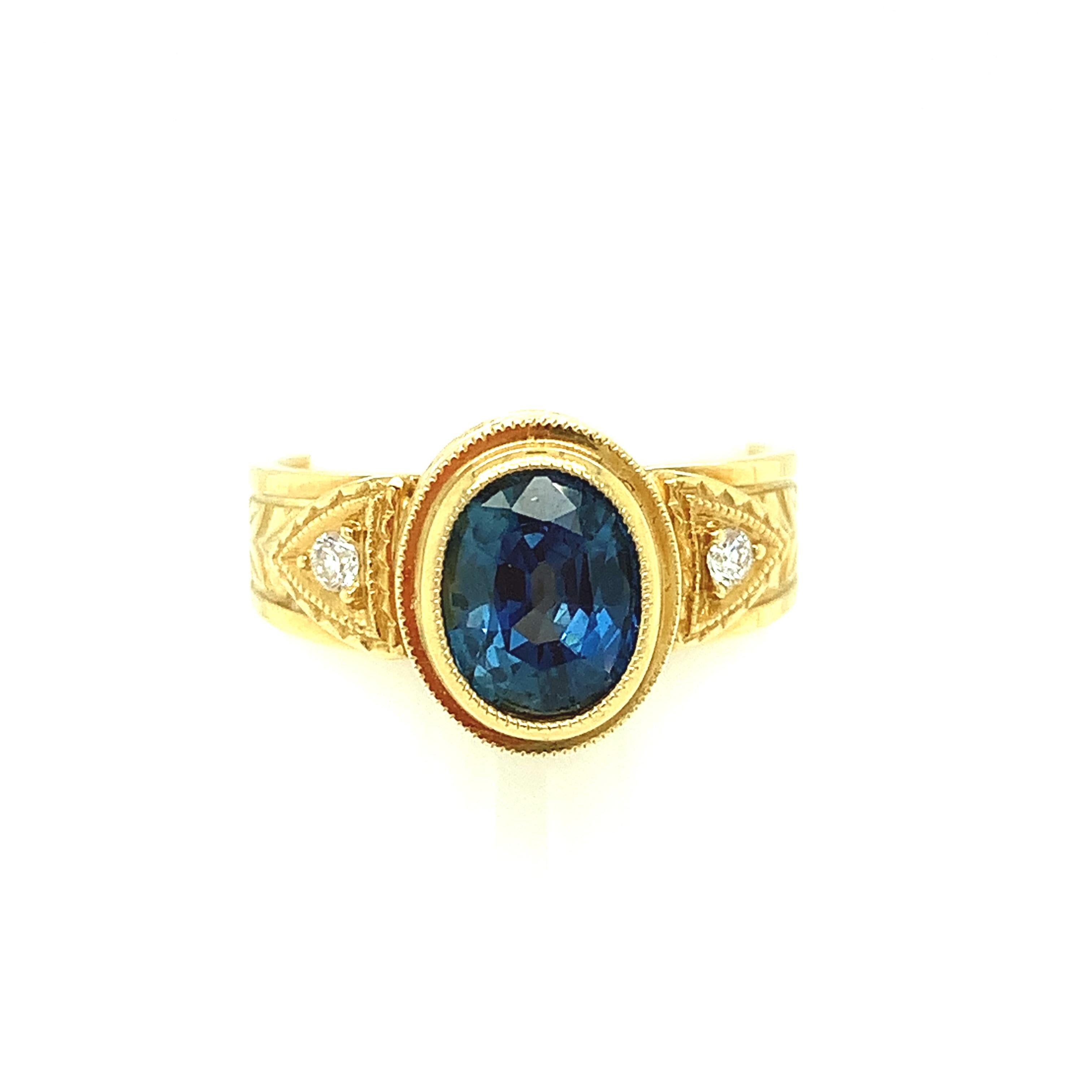 A lively, bright navy blue sapphire weighing 1.68 carats is featured in this 18k yellow gold handmade ring. This ring is part of our signature collection designed to showcase a central gemstone in a beautifully engraved handmade bezel accented with