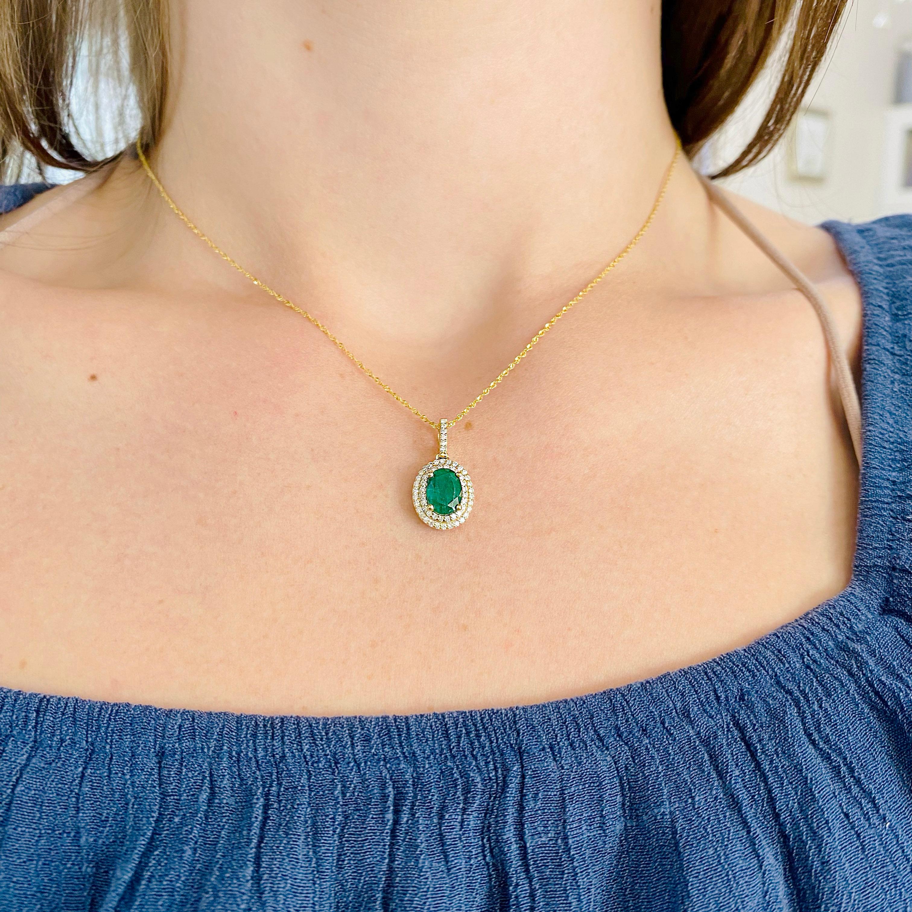 This is a fabulous emerald at a stellar price. She's a gorgeous green pendant with a double halo of diamonds in rich yellow gold. The cable link chain is a slim and durable design that goes with a variety of other necklaces and dressing up or down