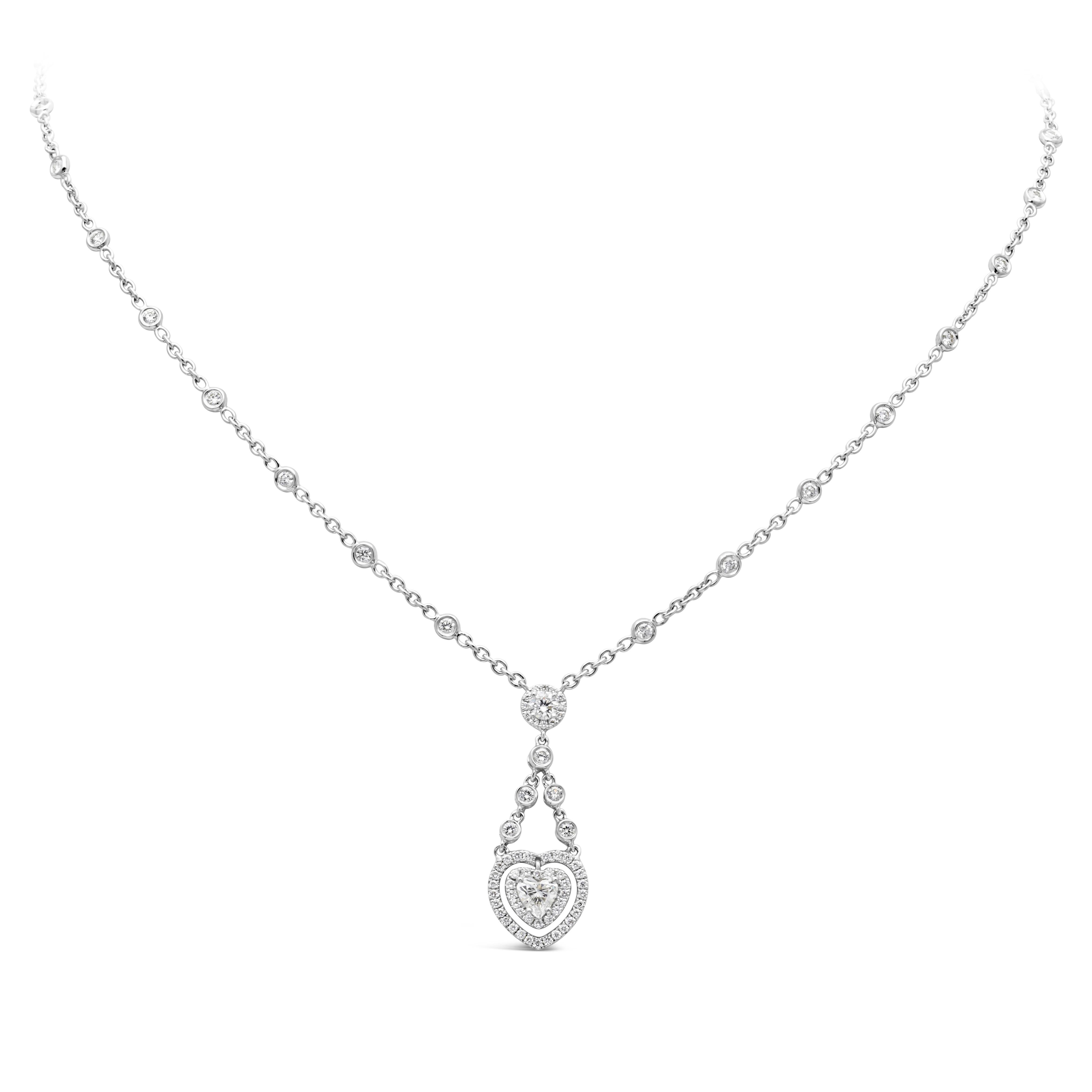 Well-crafted open work heart pendant necklace showcasing 0.40 carats heart shape diamond. Center stone is set in an open work heart shape setting clustered  with brilliant round diamonds suspended on an elegant diamond by the yard chain. 90 pieces