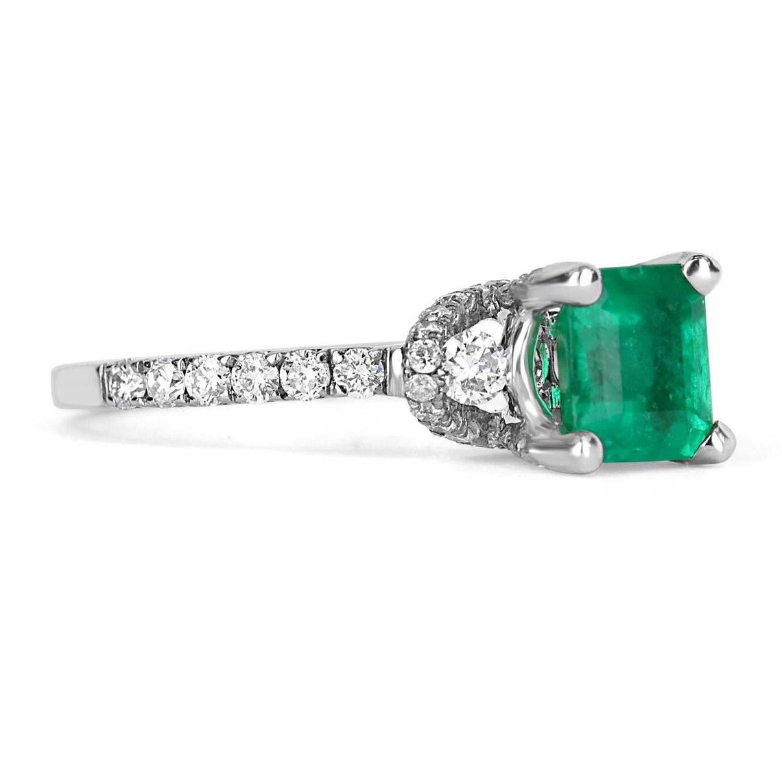 Displayed is a natural AAA+ Asscher cut Colombian emerald and diamond accent engagement ring. The center gem is a fine quality, earth mined, emerald filled with life and brilliance! Among the emeralds, impressive qualities are its vibrant color and