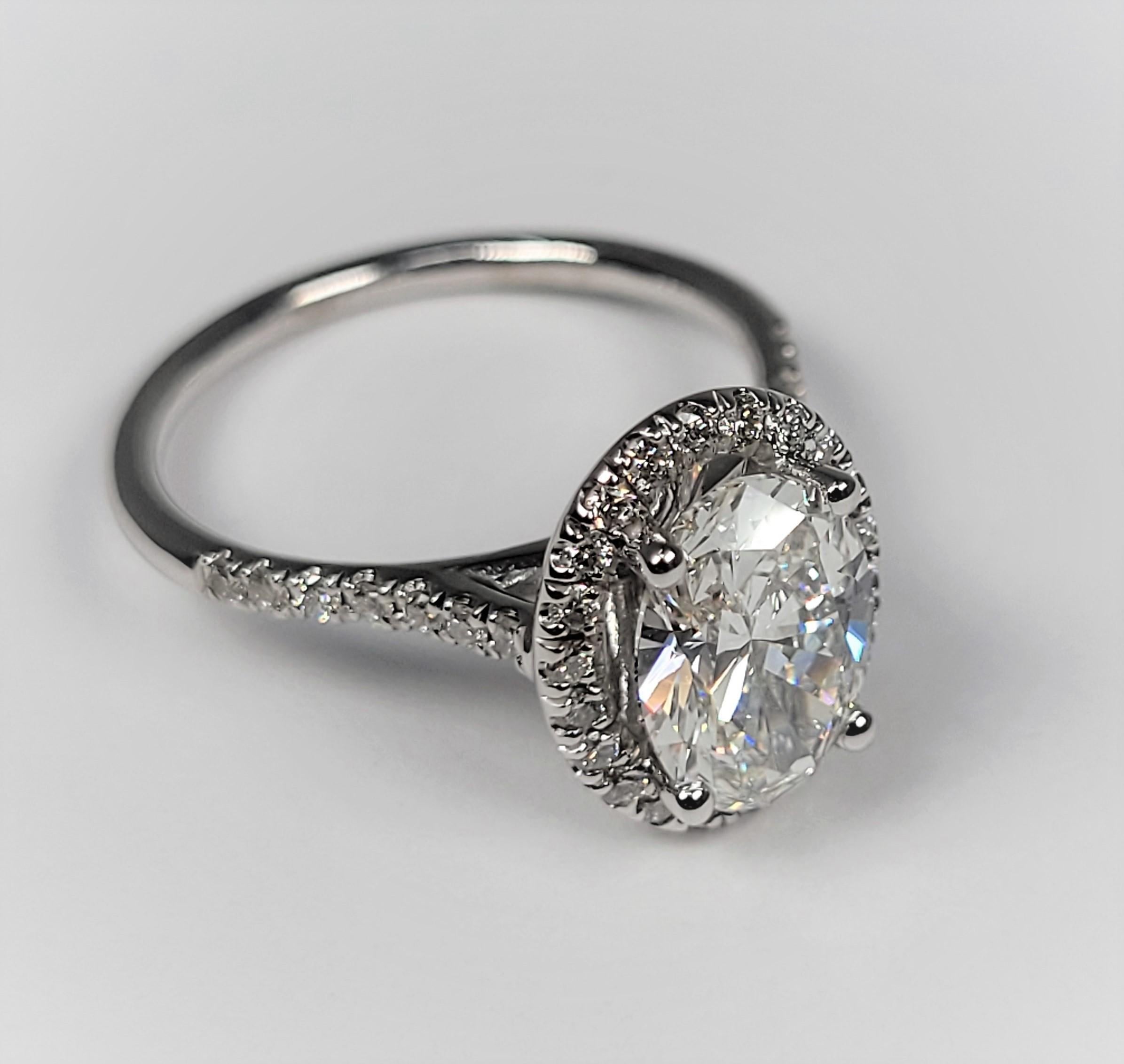 This stunning 18 karat white gold and diamond ring is a beauty!  The center is accompanied by a GIA grading report which lists the stone as a 1.69 carat oval, SI 2 in clarity and G in color.  There are an estimated 0.45 carats of side stones