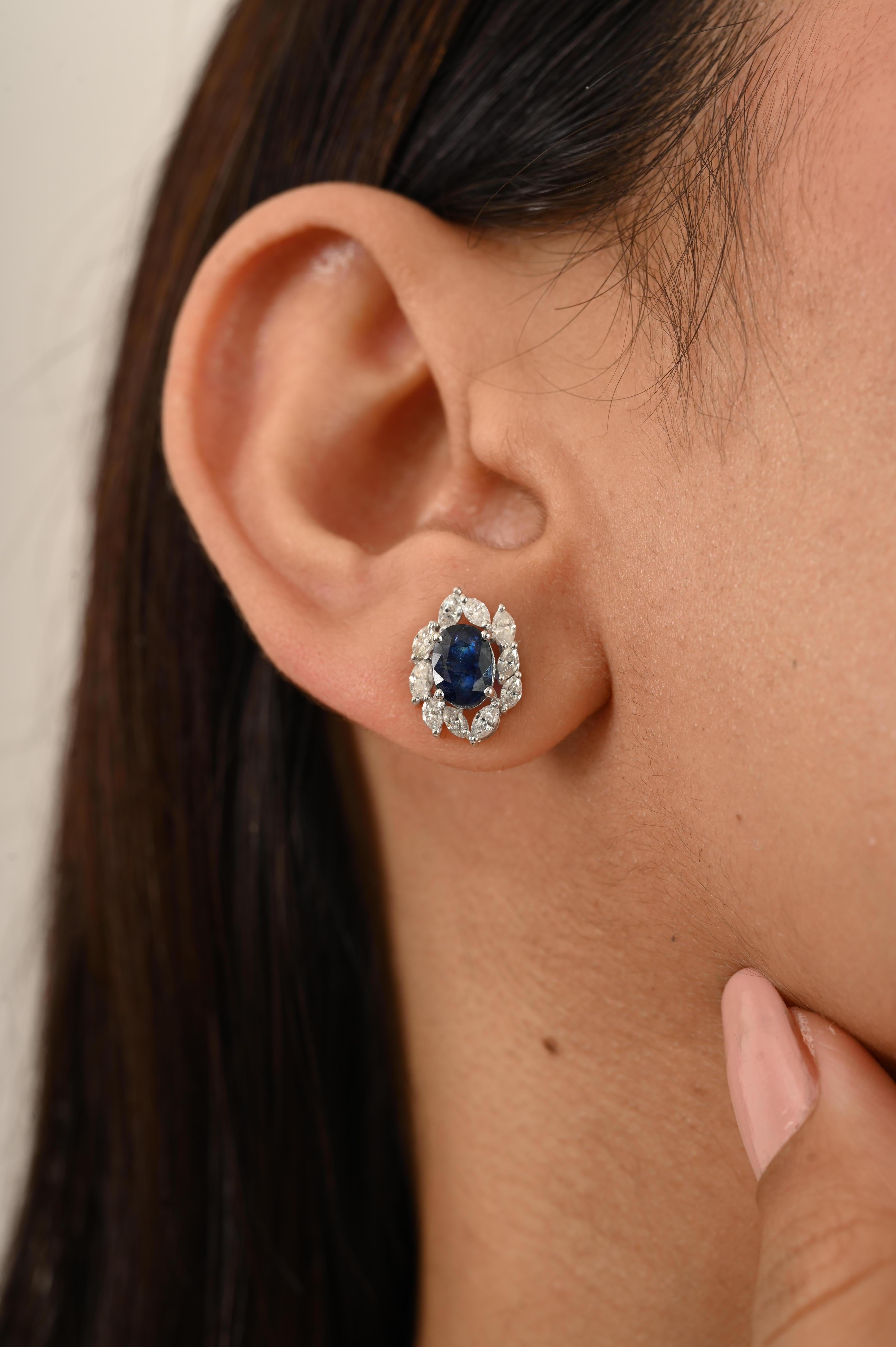 These stunning Blue Sapphire & Diamond Cluster Stud Earrings in 14K White Gold. Featuring 1.69 carats of rich, oval-cut blue sapphires encircled by a dazzling 0.76 carats halo of brilliant-cut diamonds. Sapphire stimulate concentration and reduces