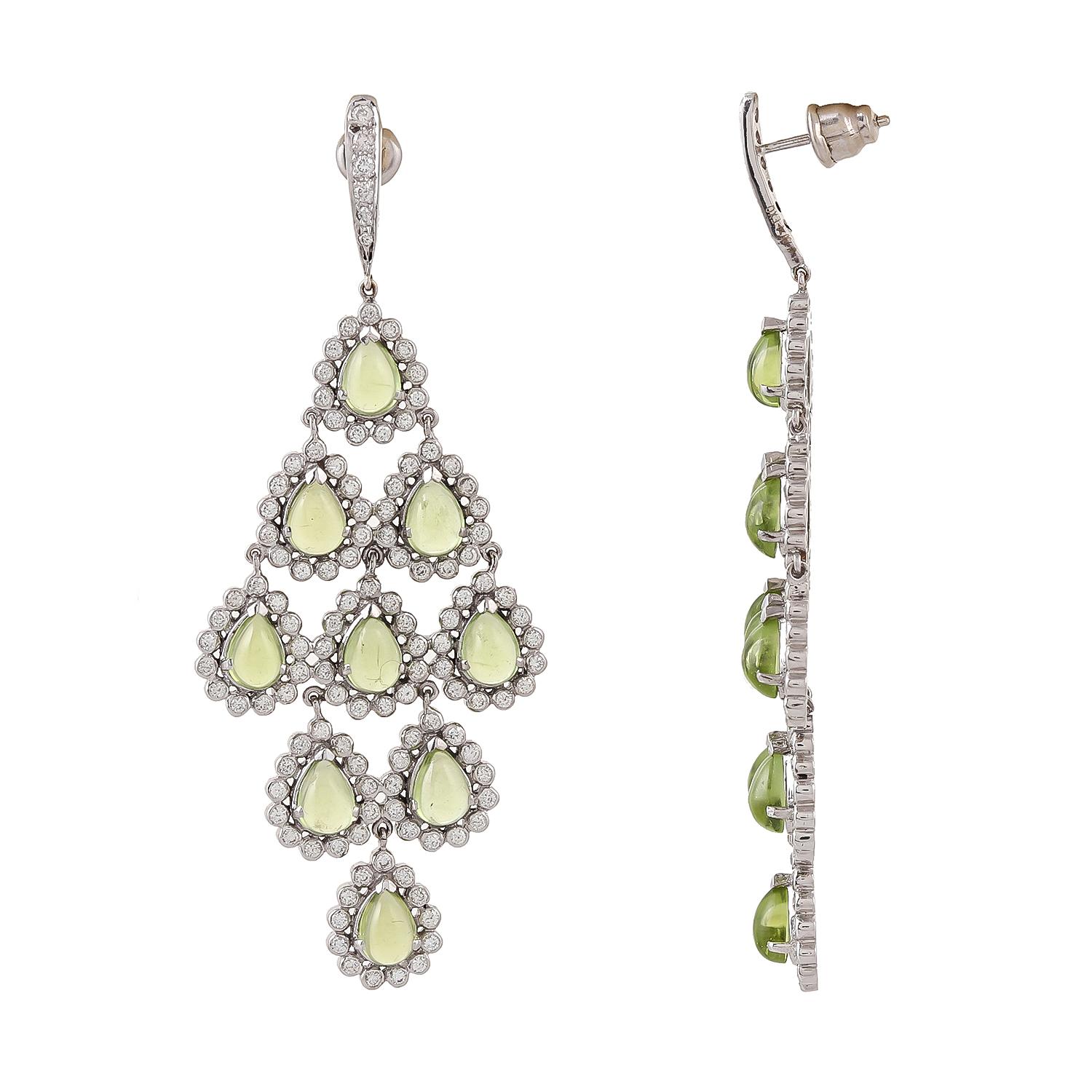 Perfectly cut 16.90 peridot cabochons pear shapes are set in such an orderly manner. These Chandeliers are in 18kt white gold and bezel set 3.38ct diamonds.