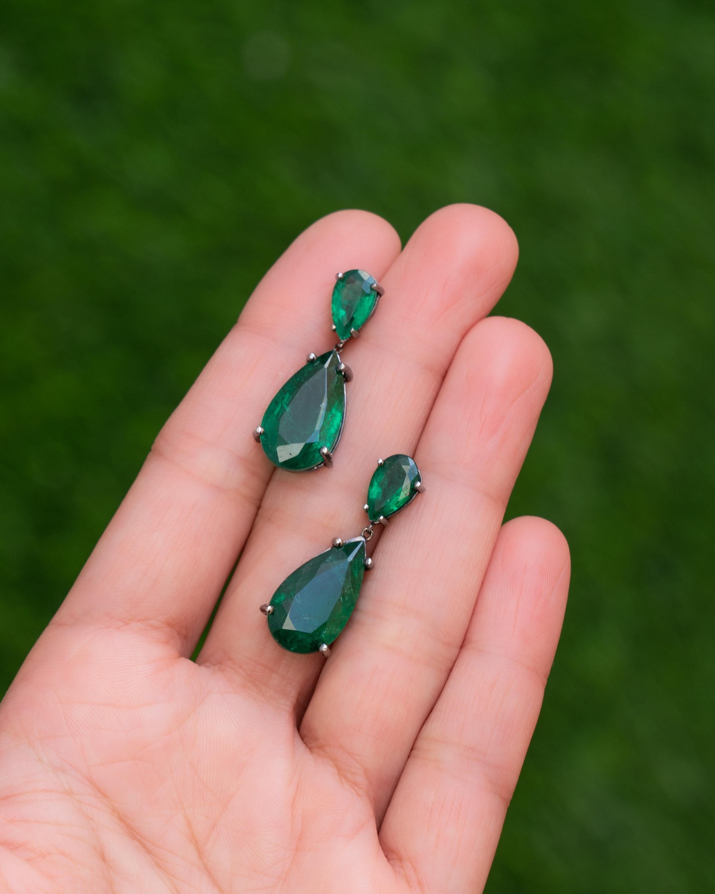 A classic pair of pear-shaped 16.98 carat Zambian Emeralds earrings, set in black rhodium plated 18K Gold. The Emeralds are of top quality, they are transparent with great luster and vivid green color. 
The earrings come with a push-pull backing,