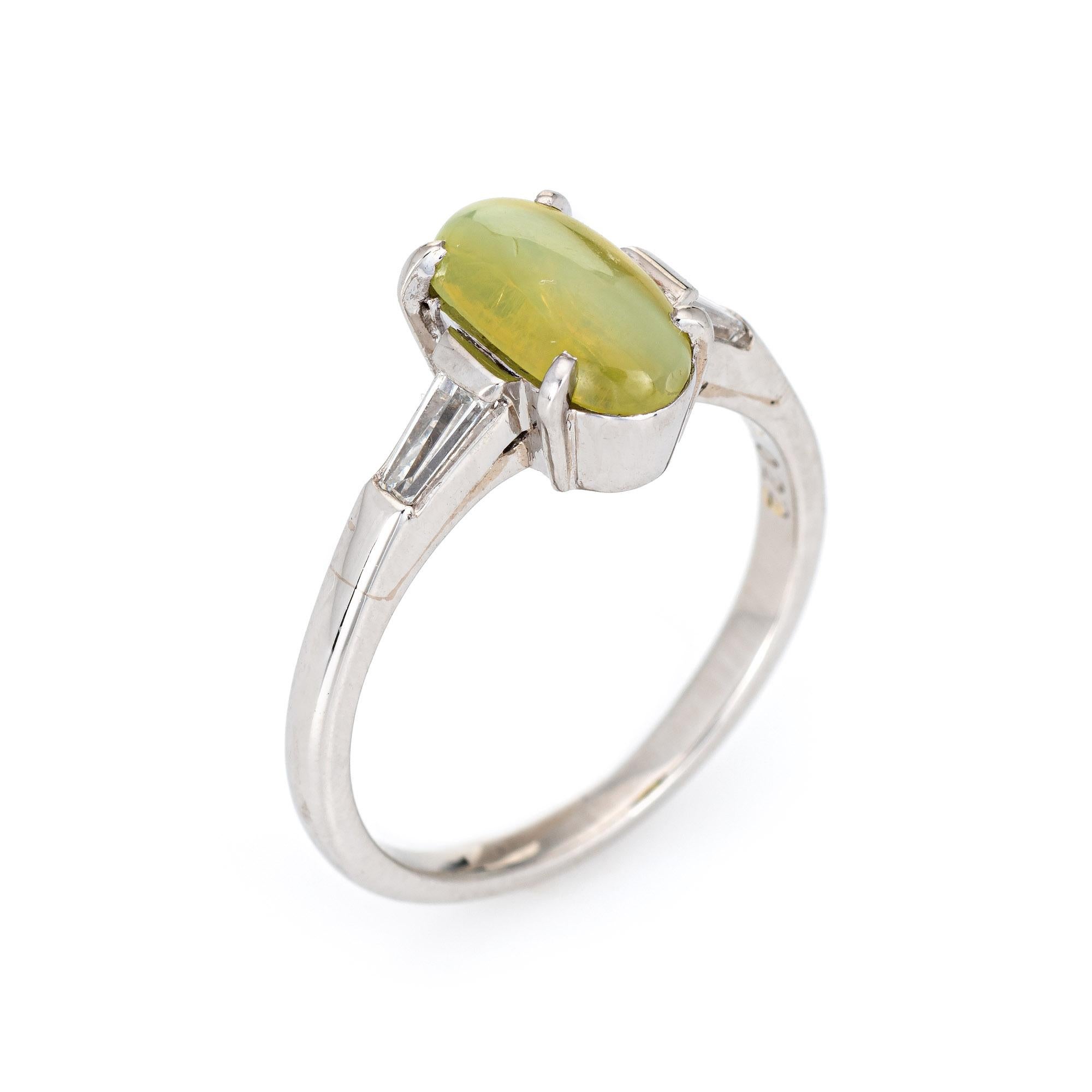 Stylish cat's eye chrysoberyl & diamond cocktail ring crafted in 900 platinum. 

Cat's eye chrysoberyl measures 9.4mm x 5.4mm (1.69 carats), accented with 0.22 carats of tapered baguette diamonds (estimated at G-H color and VS1-2 clarity). The cat's