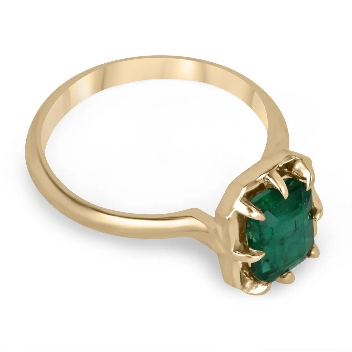 Displayed is a solitaire emerald ring. This gorgeous piece carries a full 1.69-carat Zambian emerald in an eight-prong Georgian/collet 14K yellow gold setting; with an antique finish that can be seen from the shank. Fully faceted, this gemstone