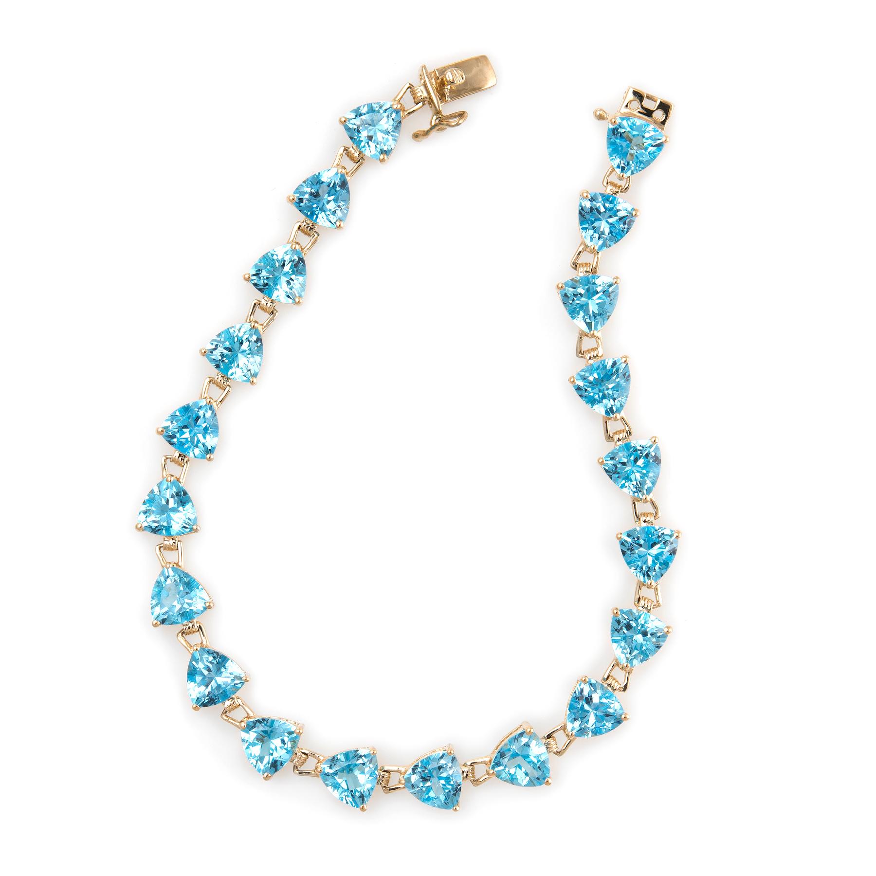 Stylish and finely detailed estate blue topaz bracelet, crafted in 14 karat yellow gold. 

20 trillion cut blue topaz measure 6mm (each) and total an estimated 16 carats. The blue topaz is in excellent condition and free of cracks or chips. 

The