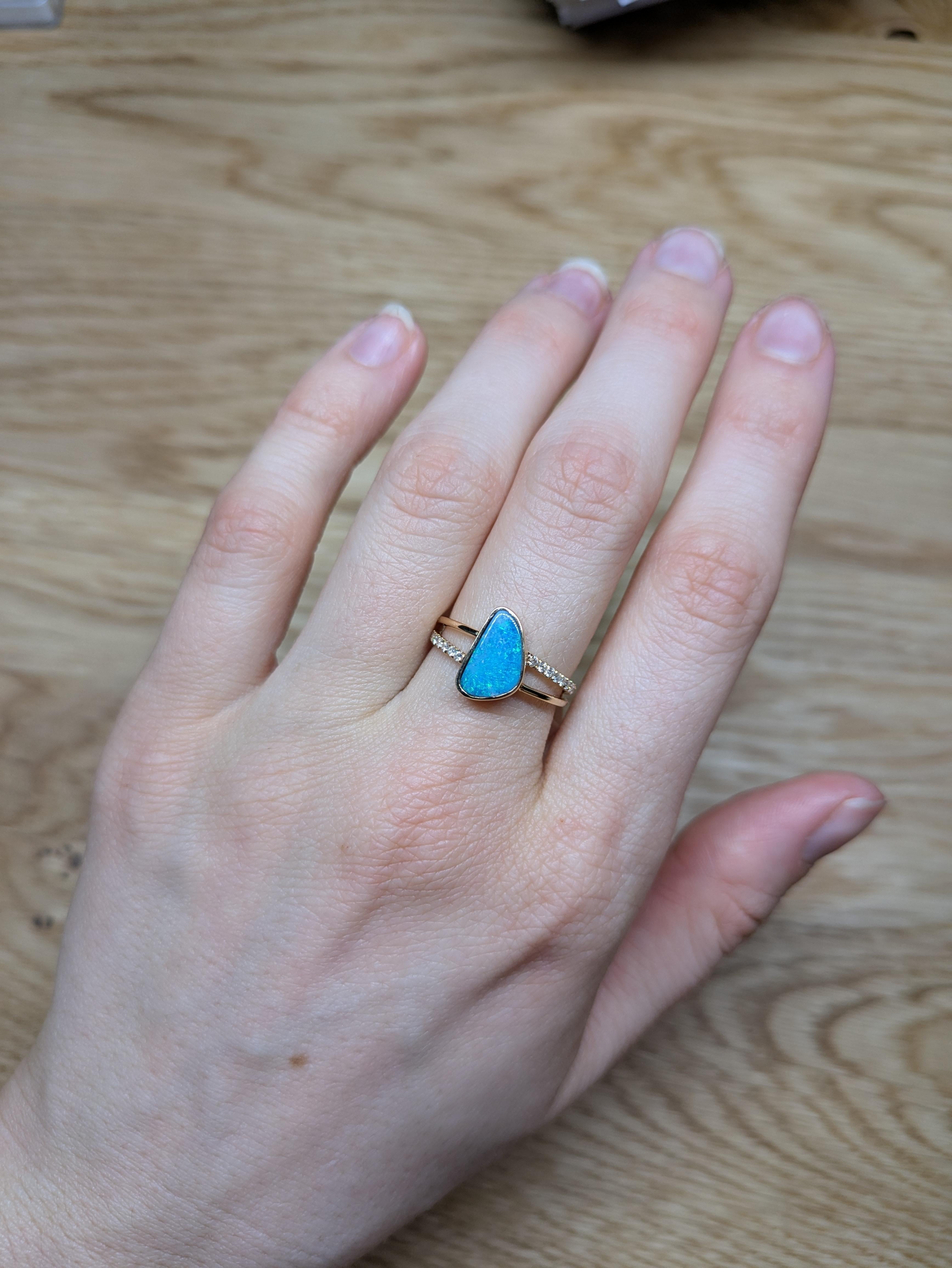 Ein 1,62 Karat schwerer Boulder-Opal mit einer organisch unregelmäßigen Form steht im Mittelpunkt dieses Rings aus 14 Karat Gelbgold. Die Lünettenfassung und der zierliche geteilte Schaft umrahmen das natürliche Feuer des Edelsteins, während