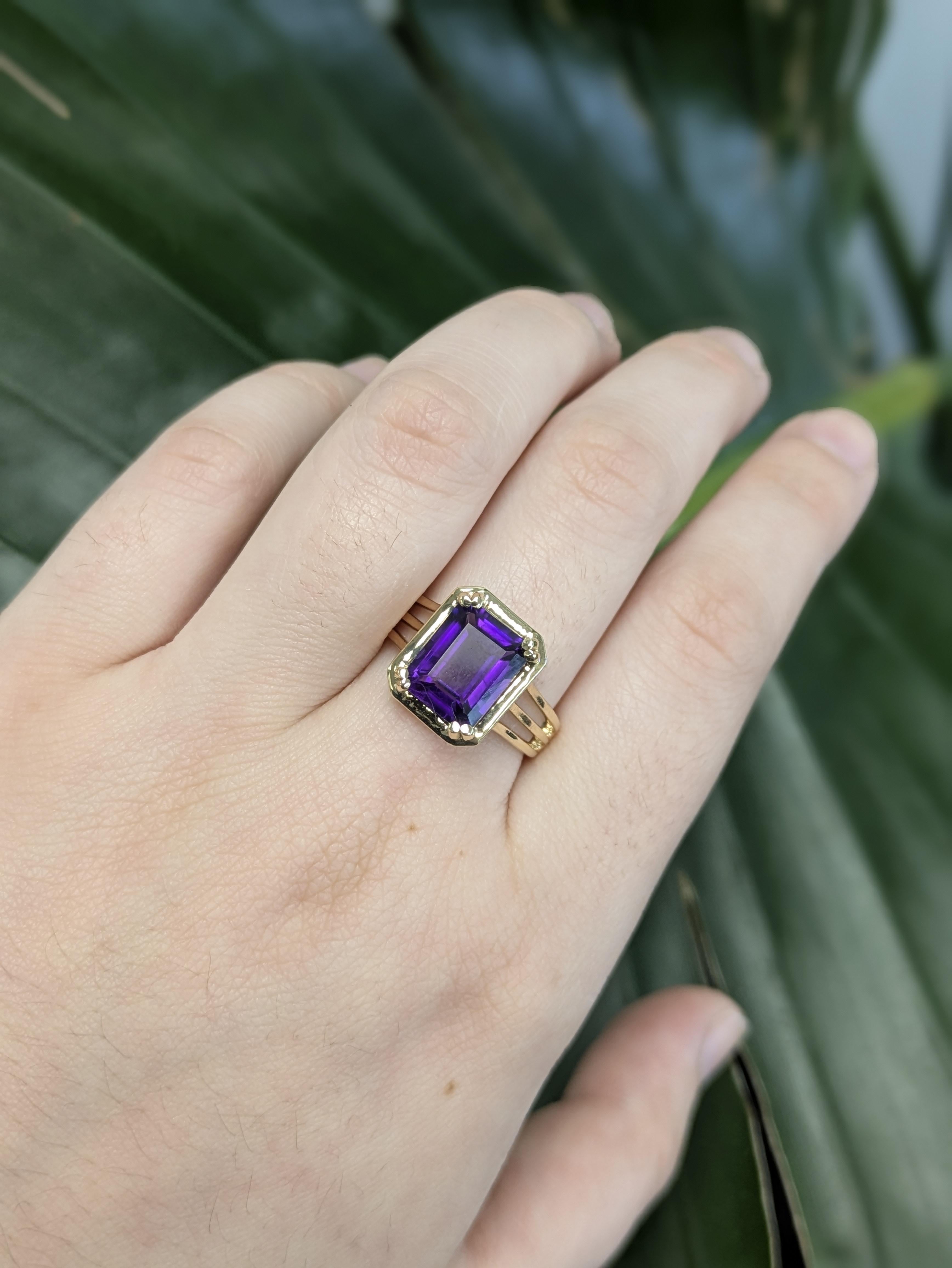 Precioso anillo de oro de 14k que exhibe una amatista talla esmeralda de 1,6 quilates (10x8 mm), realzada mediante calentamiento para profundizar su rico tono púrpura. Con una dureza de 7, esta vibrante gema ofrece elegancia y durabilidad en un