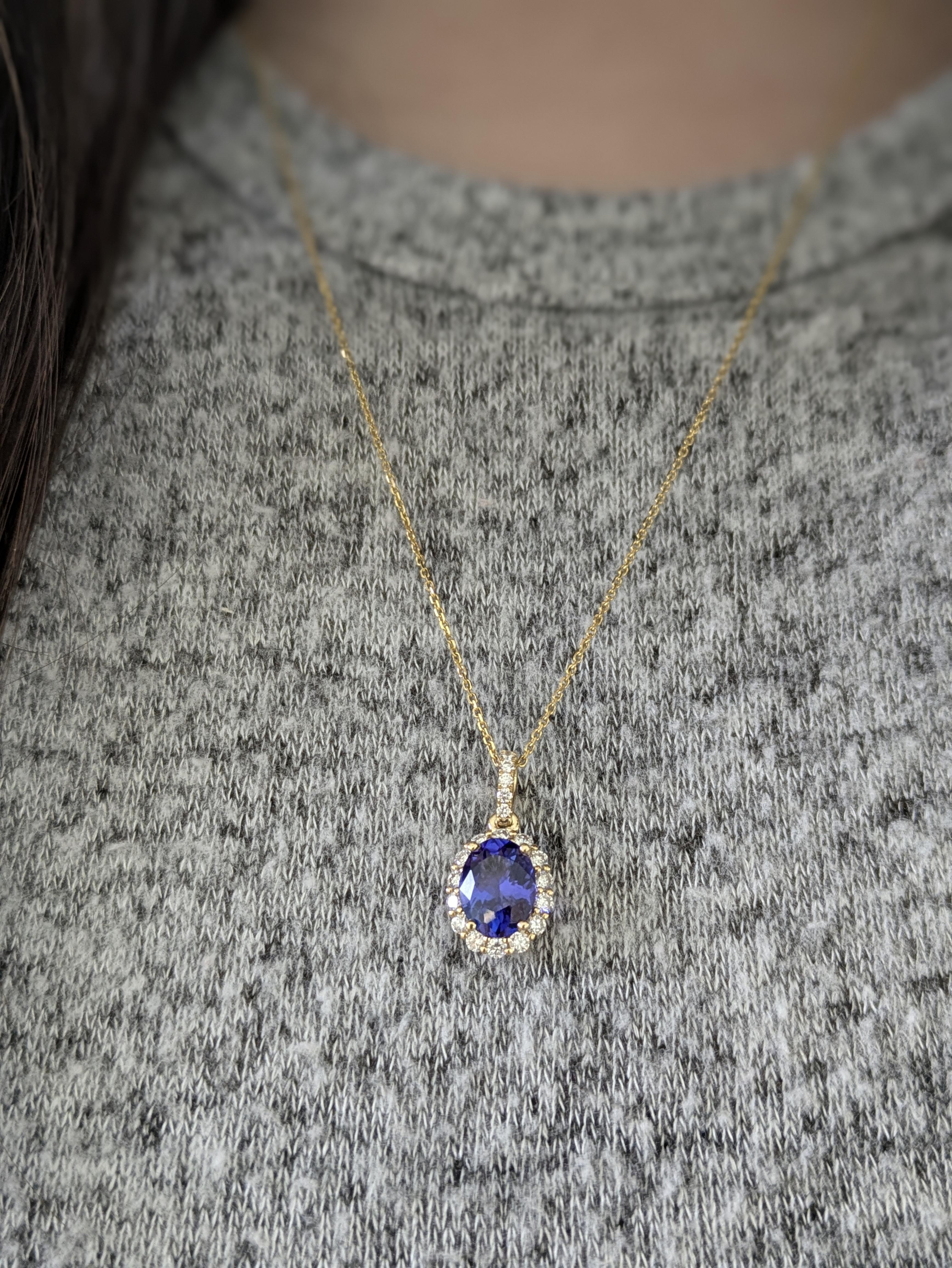 Uno squisito ciondolo ovale con tanzanite incastonata in oro giallo massiccio 14k, circondato da una radiosa aureola di diamanti naturali. Questo splendido pezzo cattura il perfetto equilibrio tra colori vivaci, eleganza senza tempo e lusso