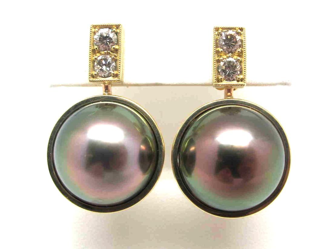 Two giant  South Sea pearls, each measuring 16 millimeters in diameter, are featured in these beautiful earrings. The pearls have a bronze/milk chocolate body color with an extremely high luster of prismatic red and green overtones. They are large