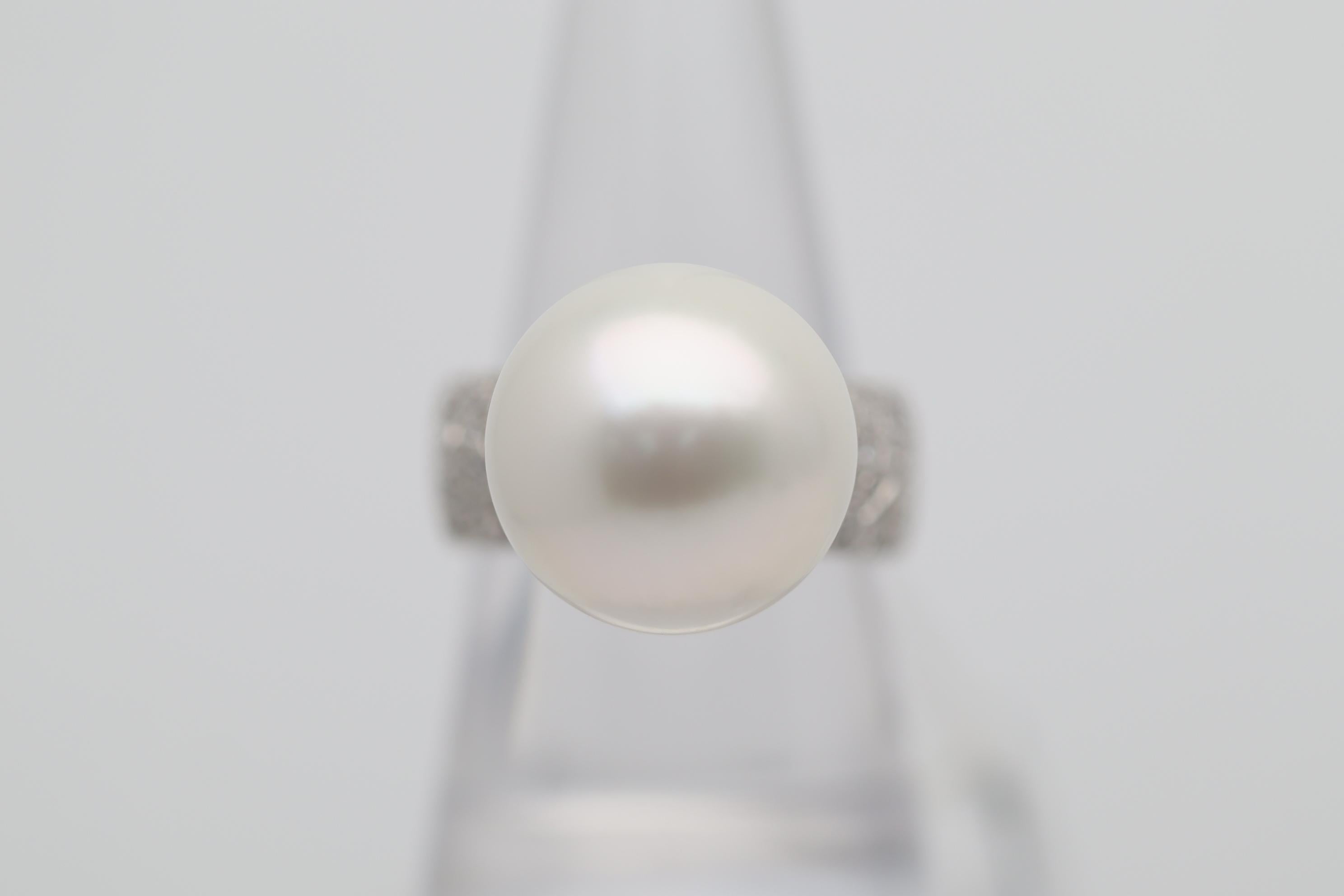 A large and impressive South Sea pearl measuring 16 millimeters in size! It has a perfectly round shape with great nacre quality and strong luster. It is complemented by 0.43 carats of round brilliant-cut diamonds set on the sides of the pearl with
