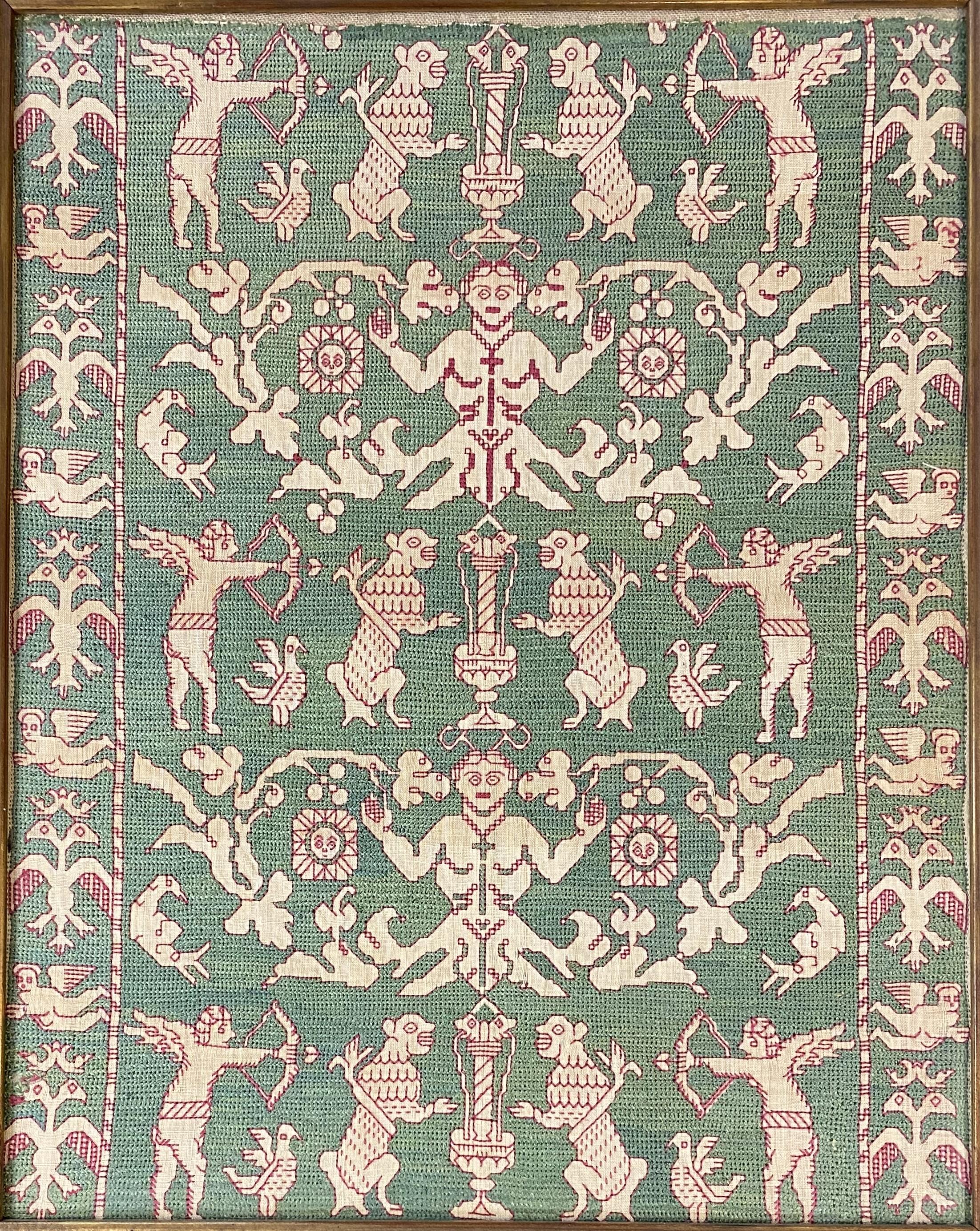 A fine example of a 16th century Spanish silk floss textile fragment from the Avila, Spain region, with embroidered angels, grotesques, and mythological animals. This textile is mounted on linen and framed under glass in a paint decorated molded