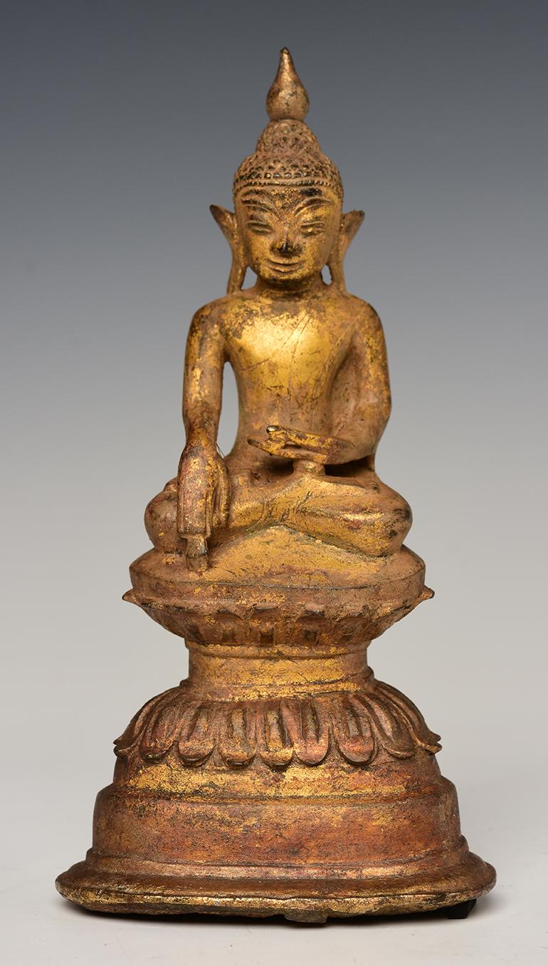 Antique Burmese bronze Buddha sitting in Mara Vijaya (calling the earth to witness) posture on double lotus base, with gilded gold.

Age: Burma, Shan Period, 16th Century
Size: Height 21.8 C.M. / Width 11.3 C.M.
Condition: Nice condition overall