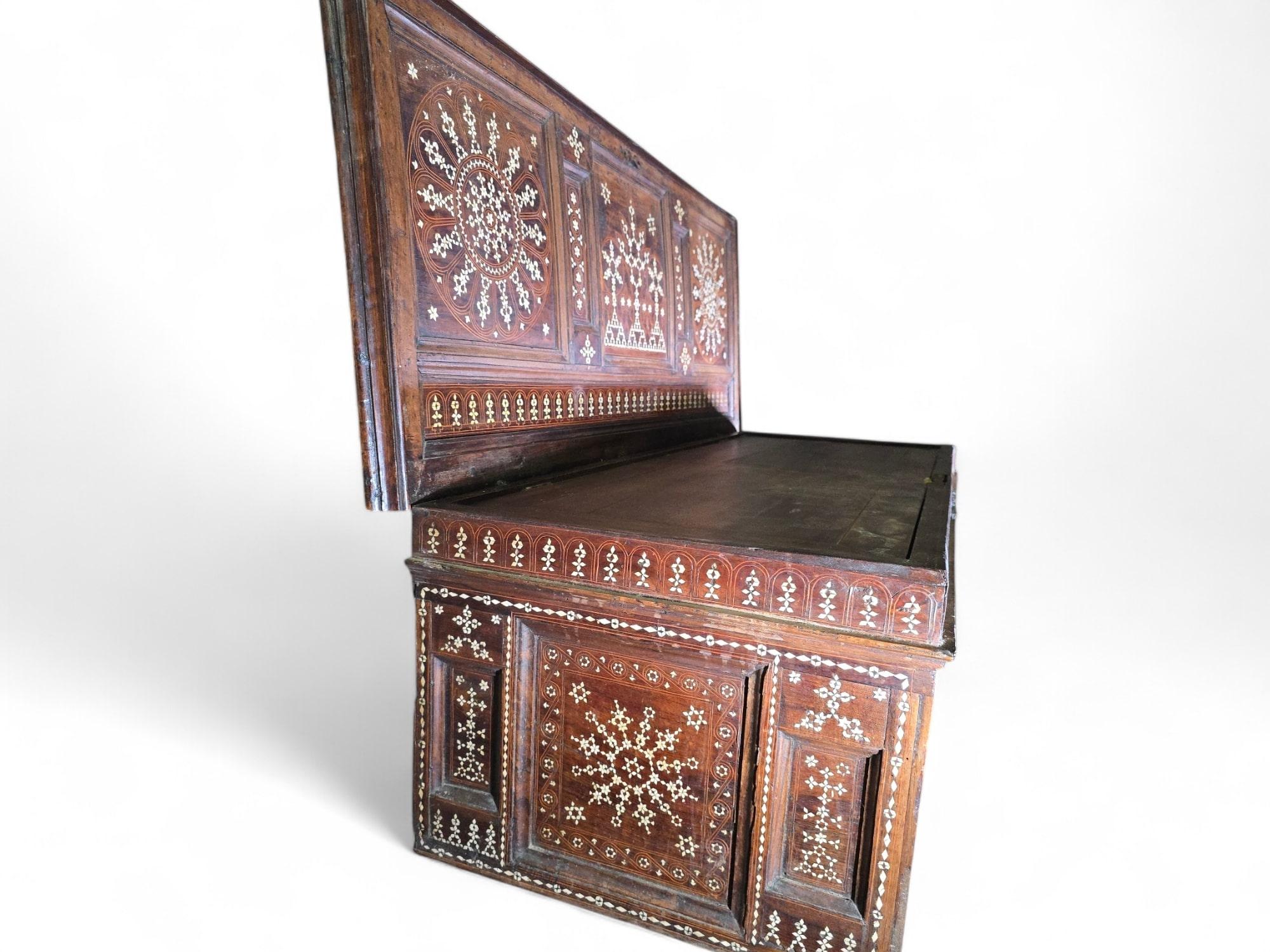 Esta excepcional arqueta del siglo XVI es un magistral ejemplo de artesanía aragonesa, que combina la rica madera de nogal con una intrincada marquetería geométrica de hueso inspirada en las tradiciones artísticas islámicas. El diseño de tapa plana
